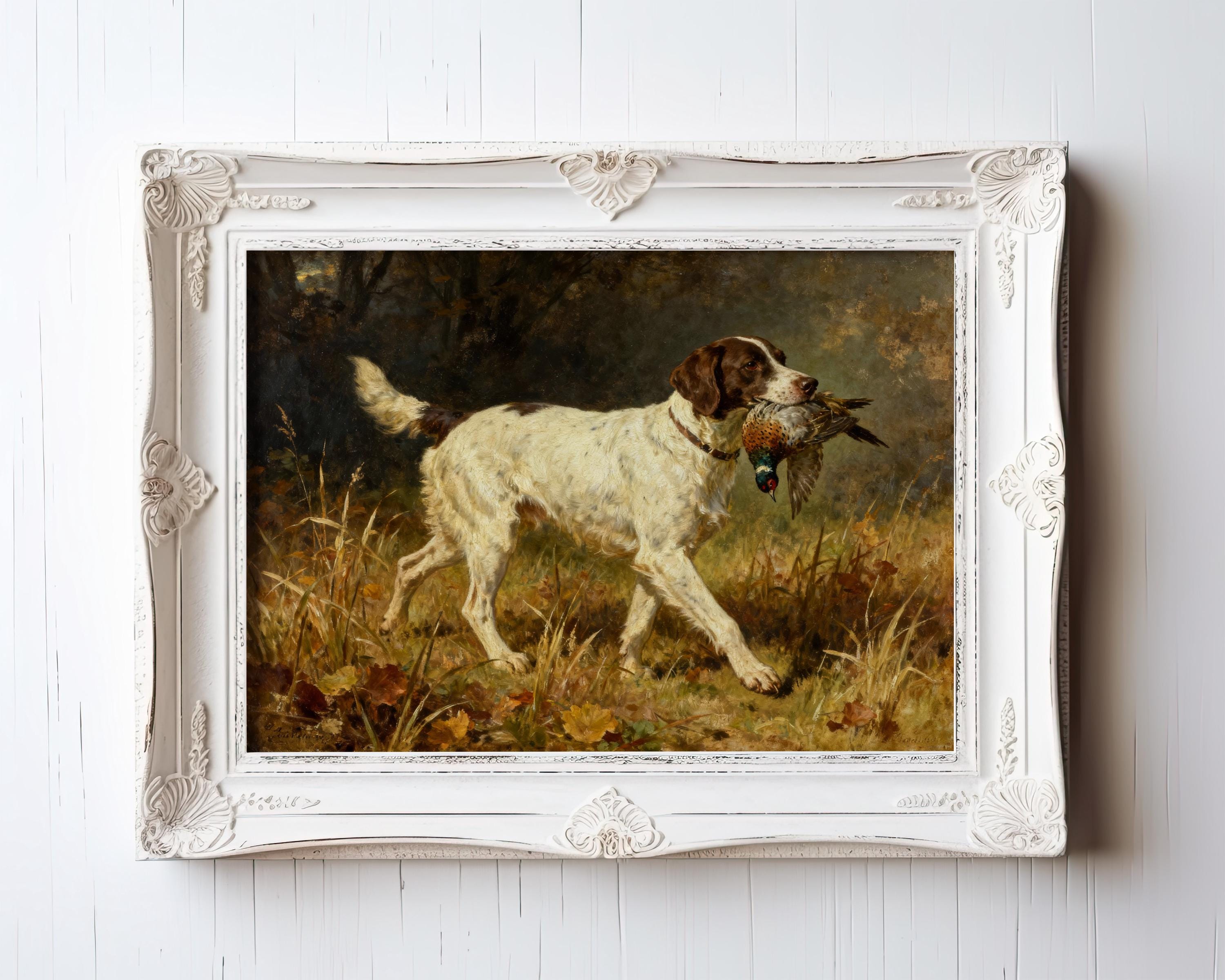 A framed painting of a white and brown dog holding a pheasant in its mouth, set outdoors in a grassy area, hangs on a white wooden wall.