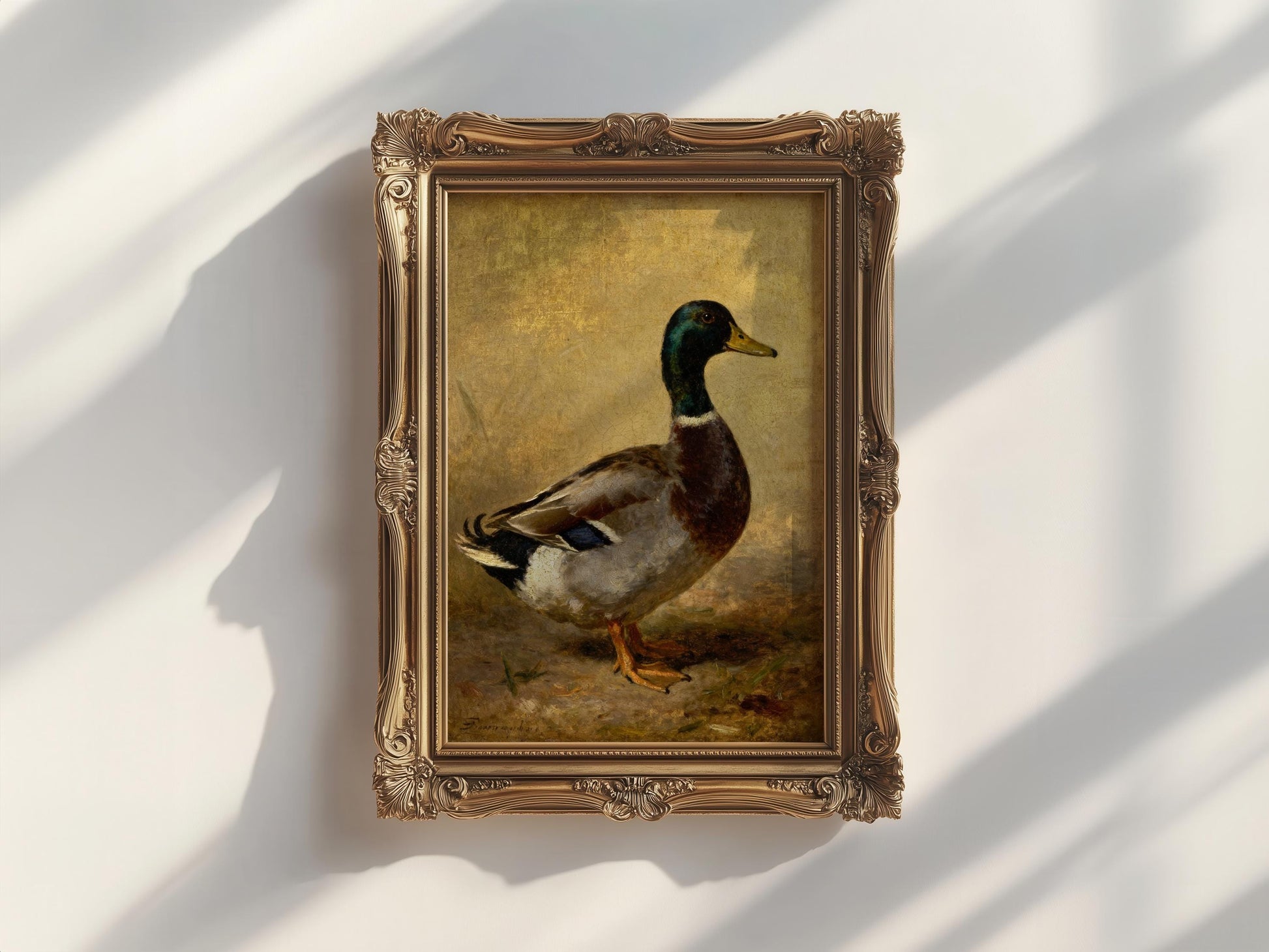 a painting of a duck in a gold frame, hanging on a white wall.
