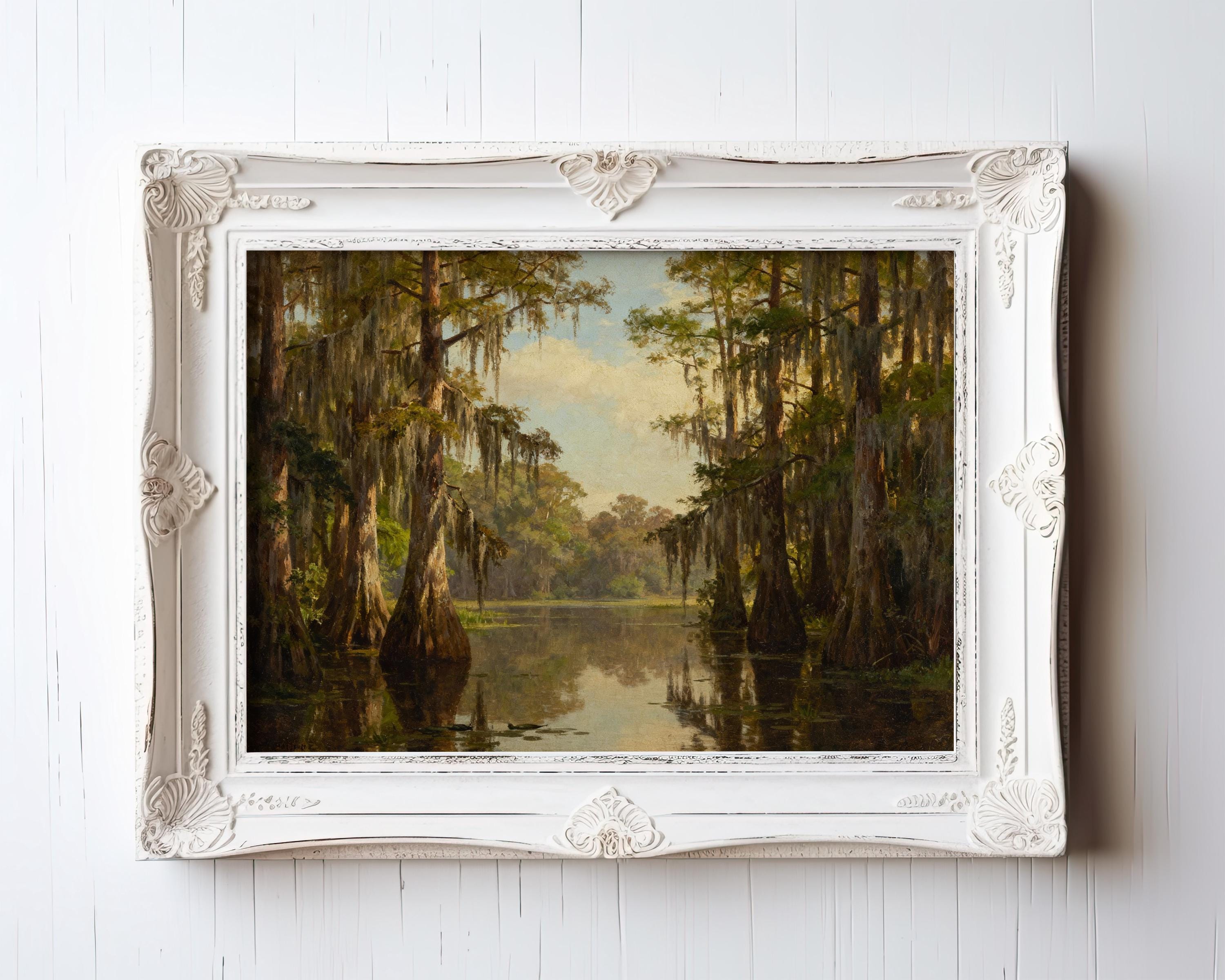 The Vintage Swamp Landscape Print – Cypress Tree Art, shown framed on a white wall, features tall cypress trees mirrored in still water. Its ornate white frame adds charm and elevates this nature print to a timeless décor piece.