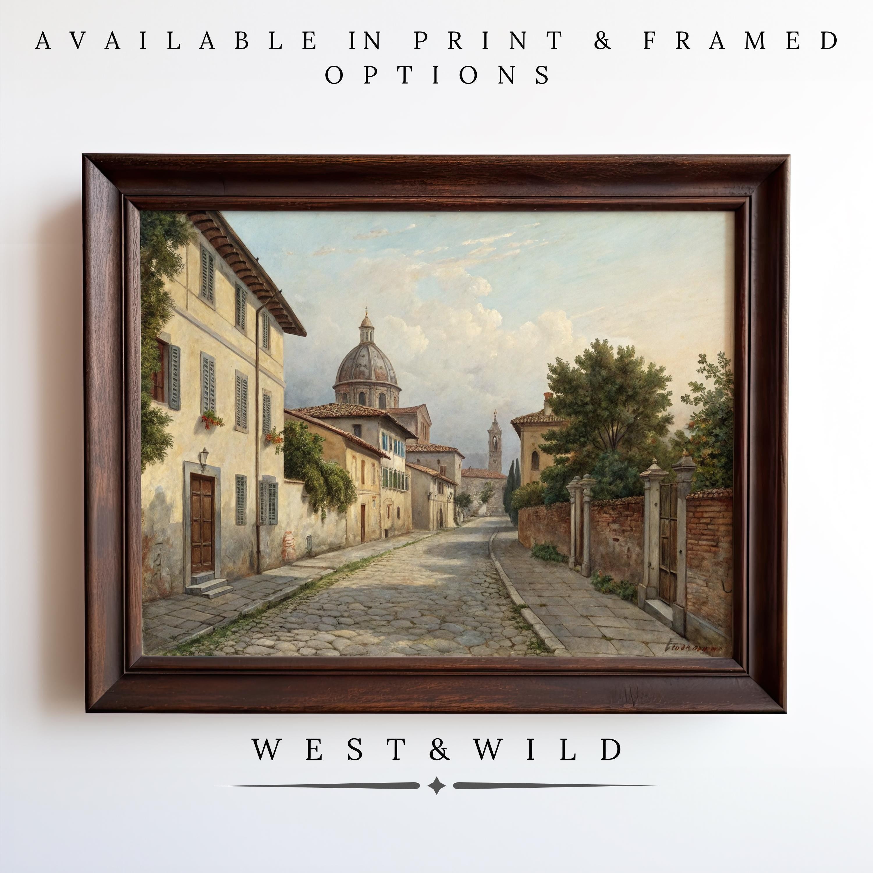 Display the “Italian Street Painting - Classic Vintage Prints” for authentic Italy home decor, featuring a cobblestone street with trees, historic buildings, and a domed landmark. Archival quality print and framing from West & Wild Art Archive.