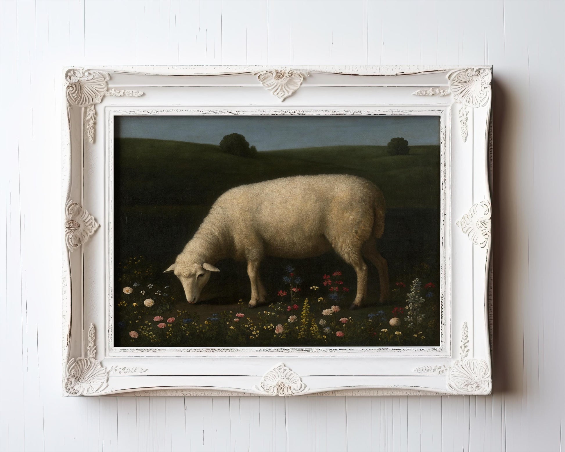 The Vintage Sheep Art Print – Pastoral Animal Print features sheep grazing among wildflowers, set in green hills under a cloudy sky. This rustic farmhouse wall décor includes an ornate white frame and is archival quality for lasting beauty.