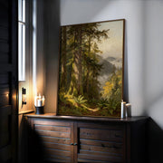 a large painting of a forest scene with tall trees and lush greenery, displayed on a wooden cabinet or shelf. The painting is illuminated by candles, creating a warm and cozy atmosphere in the room.