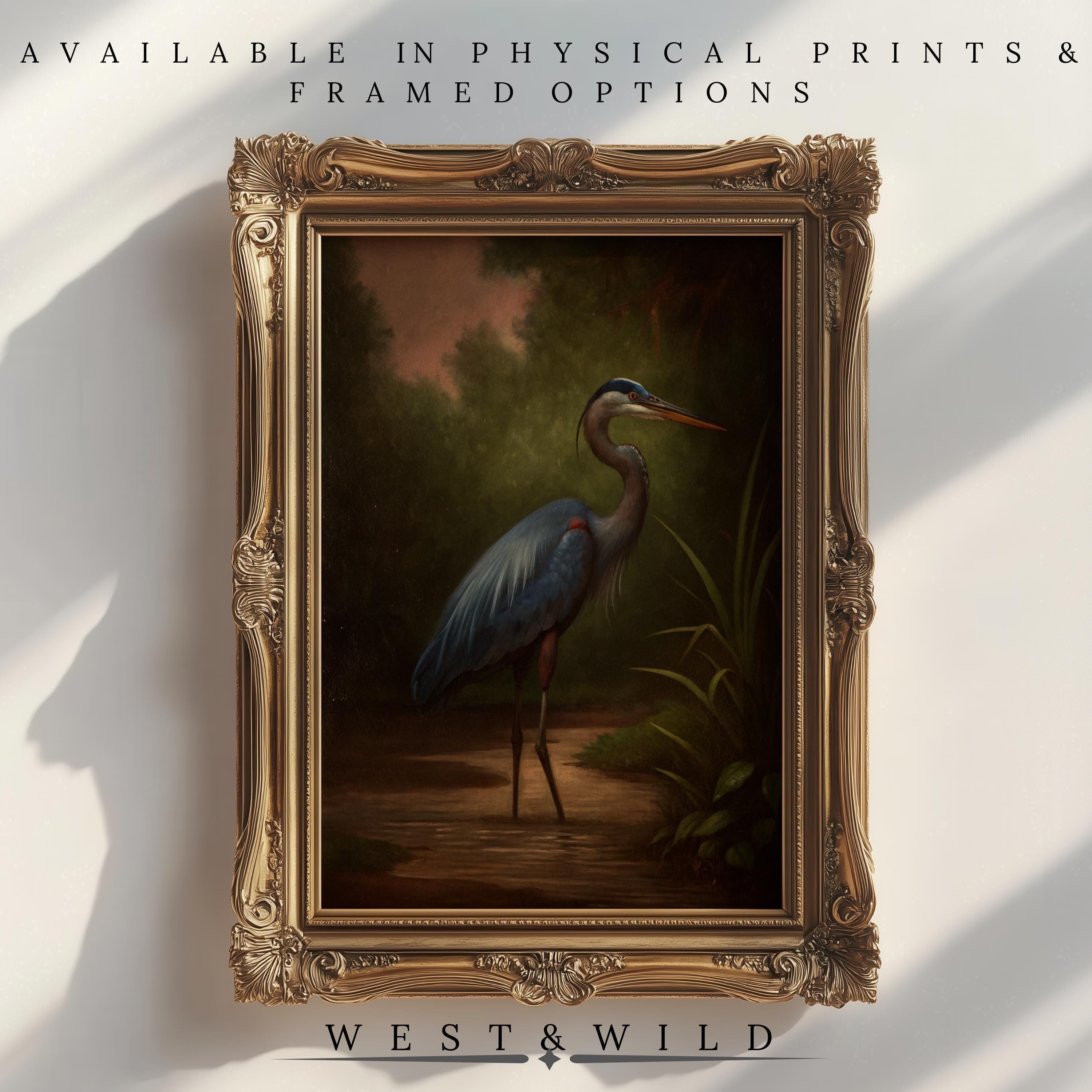 The Blue Heron Art Print - Elegant Nature Wall Decor shows the bird in shallow water amid greenery. Available as a physical print or framed, with "West & Wild" at the bottom—perfect for bringing nature into your home.
