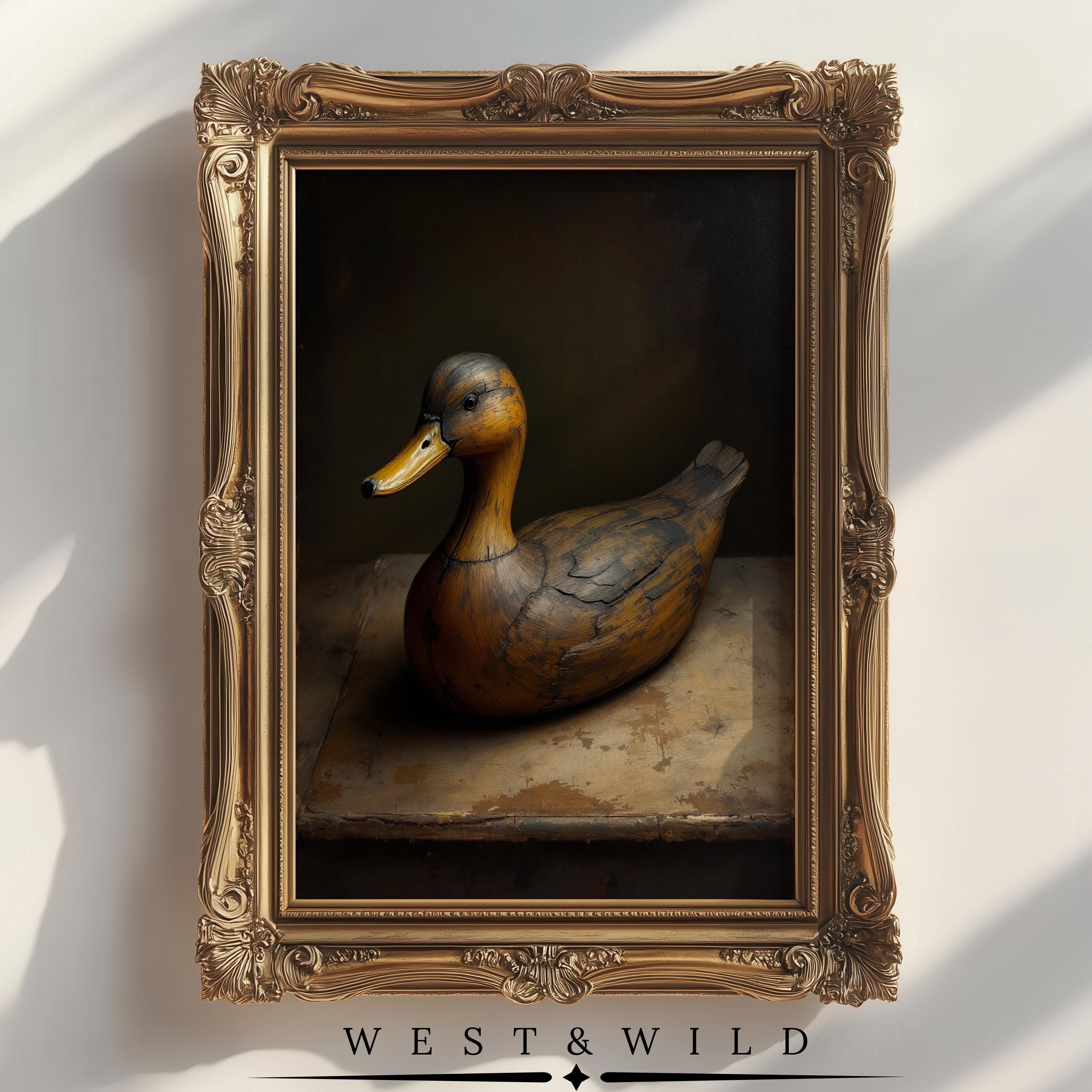The Vintage Duck Wall Art – Antique Mallard Duck Print features a wooden duck decoy under dramatic lighting, set in an ornate gold frame. This framed nursery decor gift adds classic elegance to any room.