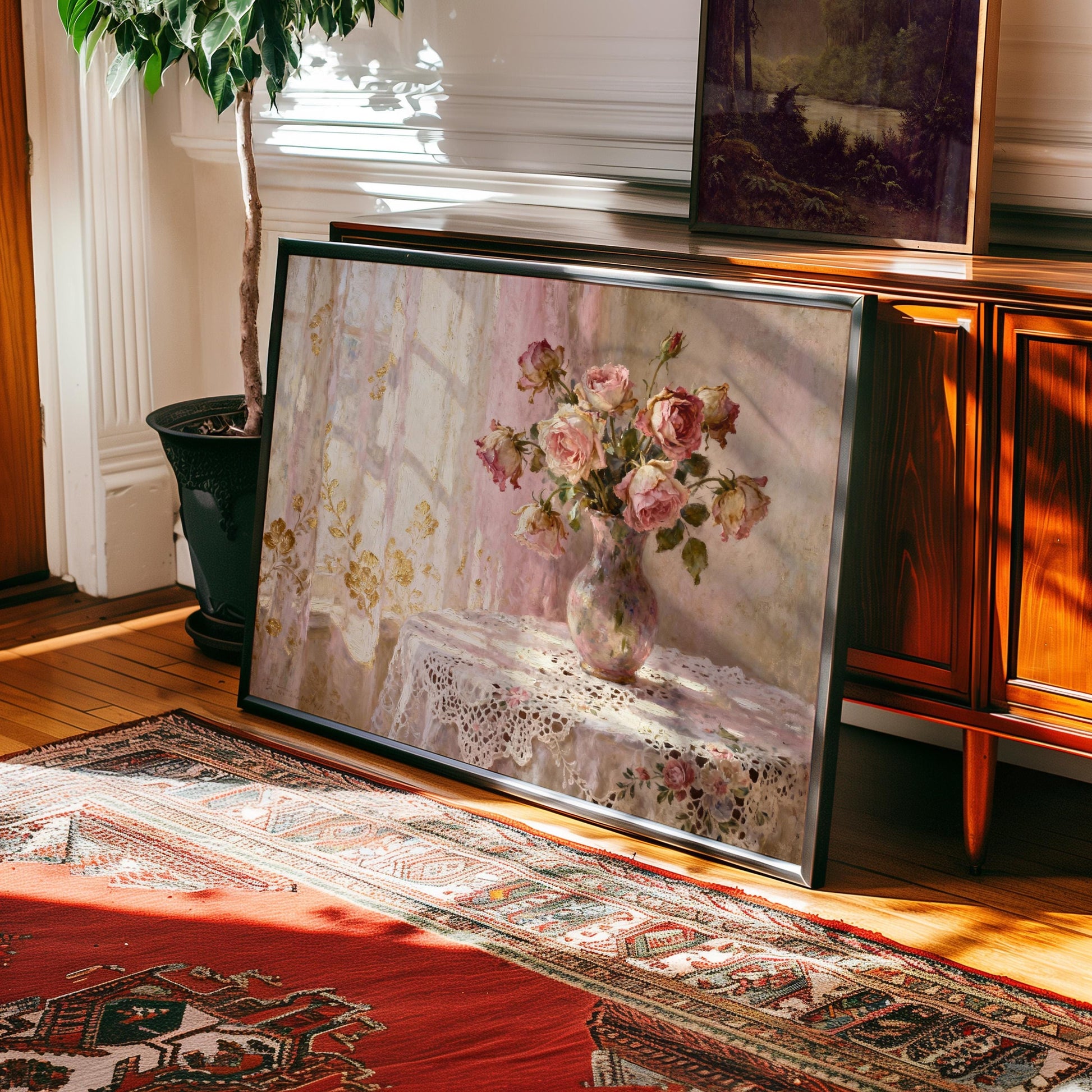 a large framed painting of a vase of pink roses on a table, placed on a rug in a room with wooden furniture.