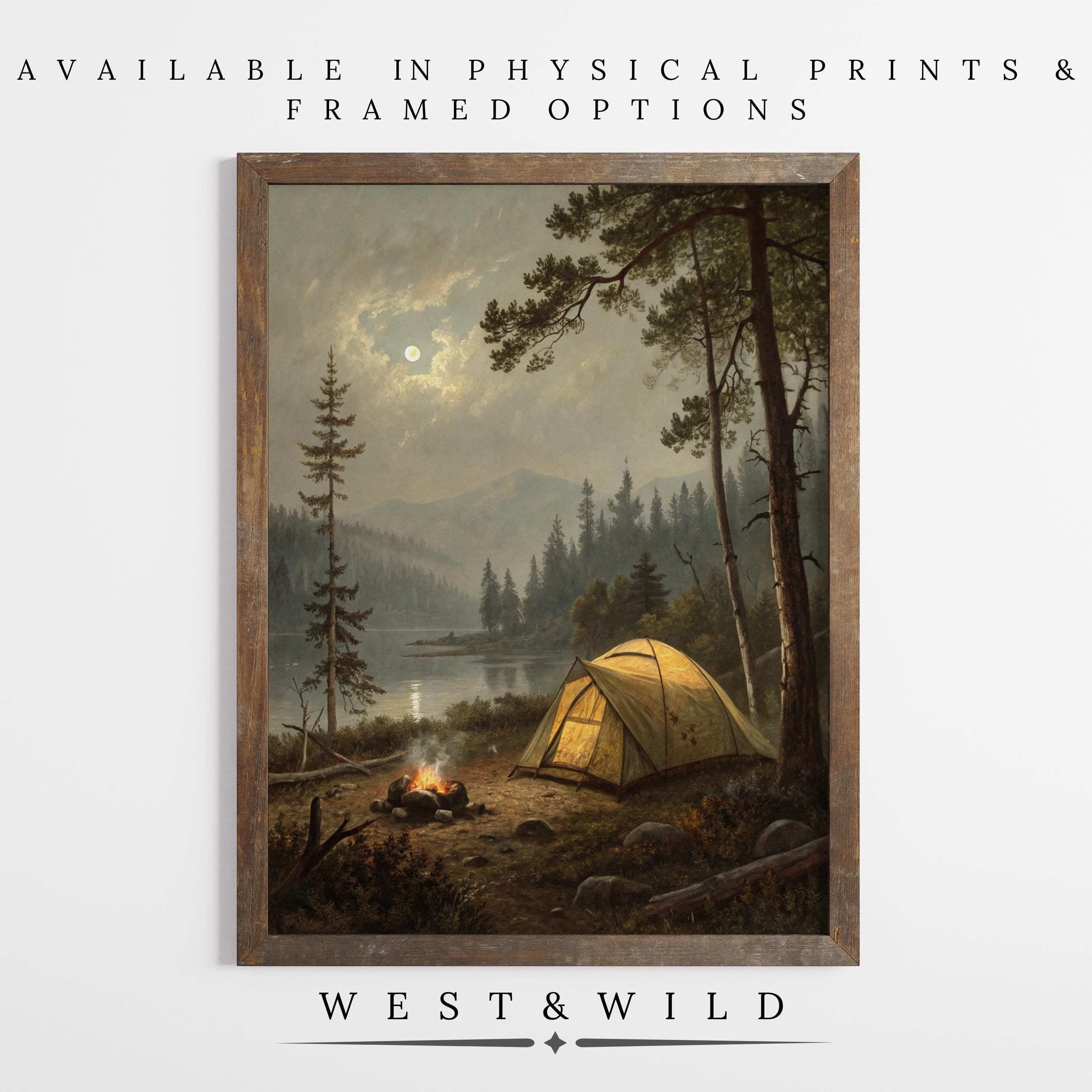 The Campfire Wall Art features a glowing yellow tent and campfire by a moonlit lake, offered as vintage or framed prints with archival quality by West & Wild—perfect rustic tent wall decor for camping lovers.