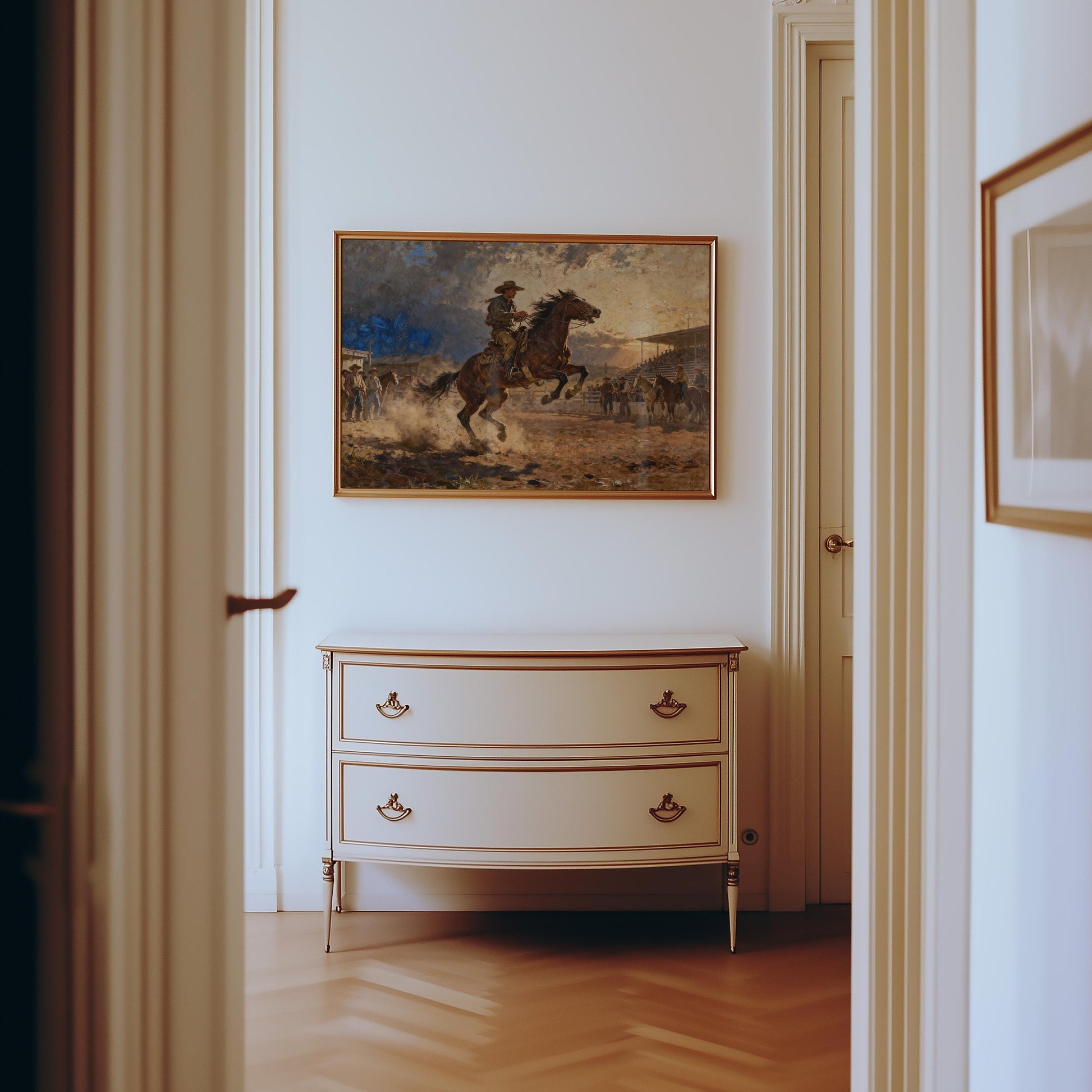 a hallway with a painting of a man on a horse hanging on the wall above a white dresser with two drawers.