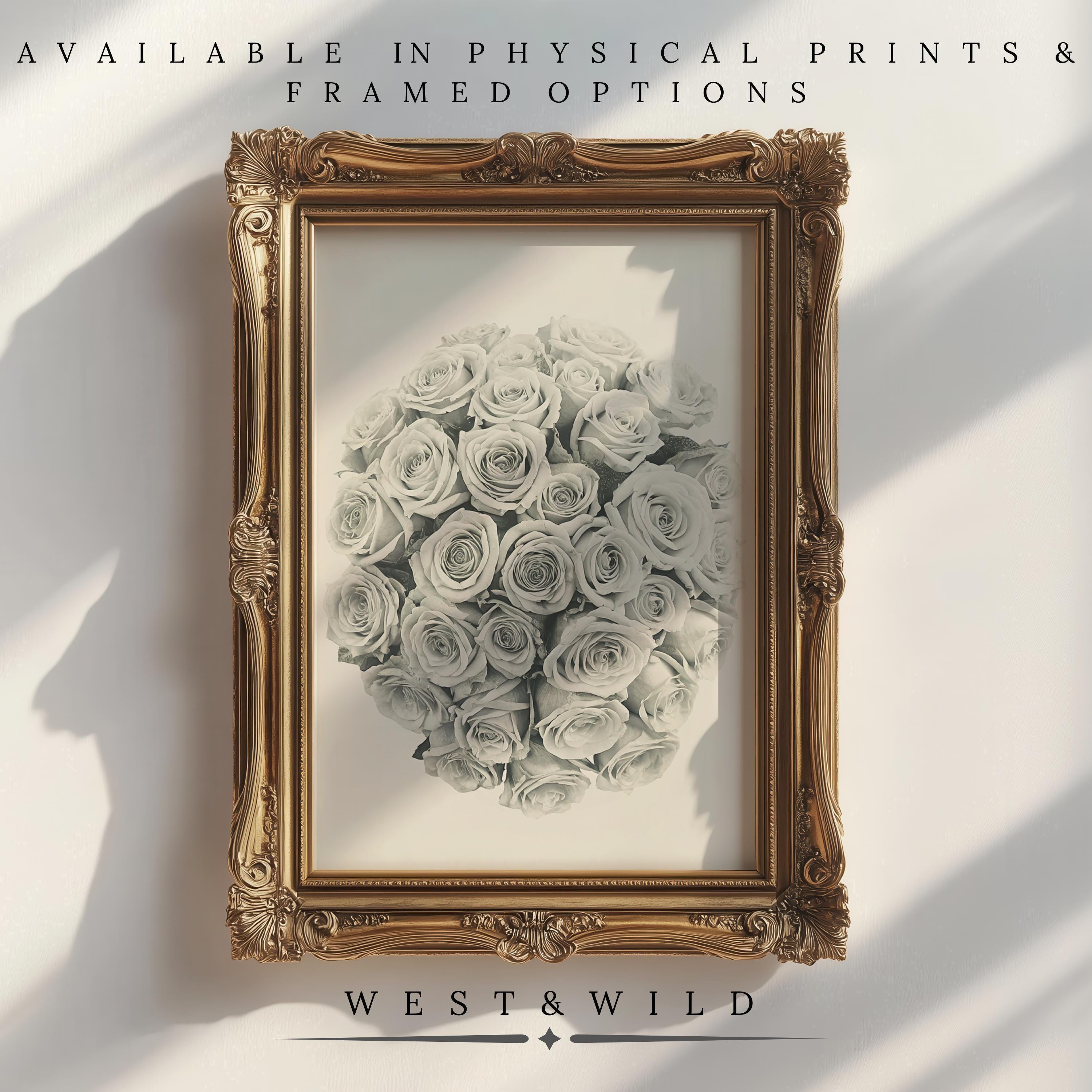 A gold ornate frame holds the White Roses Art Print – Elegant Floral Wall Decor | Classic Rose Bouquet Print. Available as physical prints & framed options from West & Wild, sunlight casts soft shadows on this classic floral wall decor.
