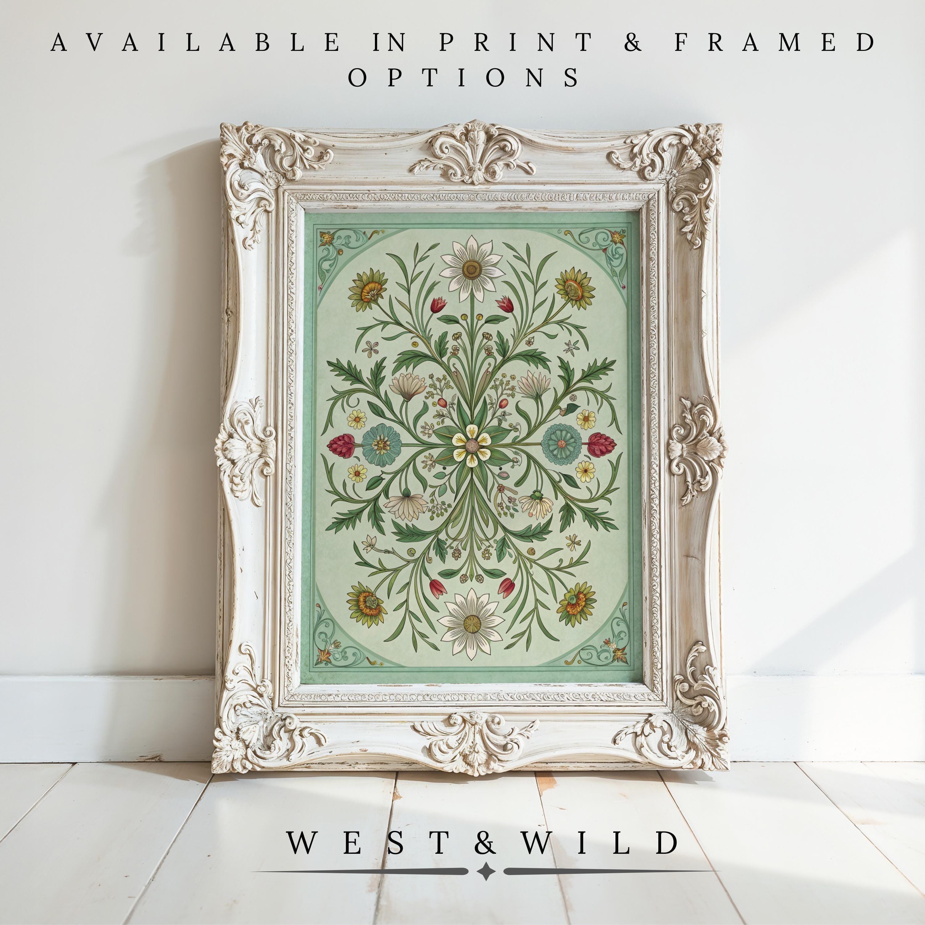 Vintage Floral Painting – Framed Botanical Wall Art features an ornate white frame showcasing vintage floral patterns on pale green. Text above: Available in print & framed options. Below: West & Wild. Frame sits on a white wooden floor.