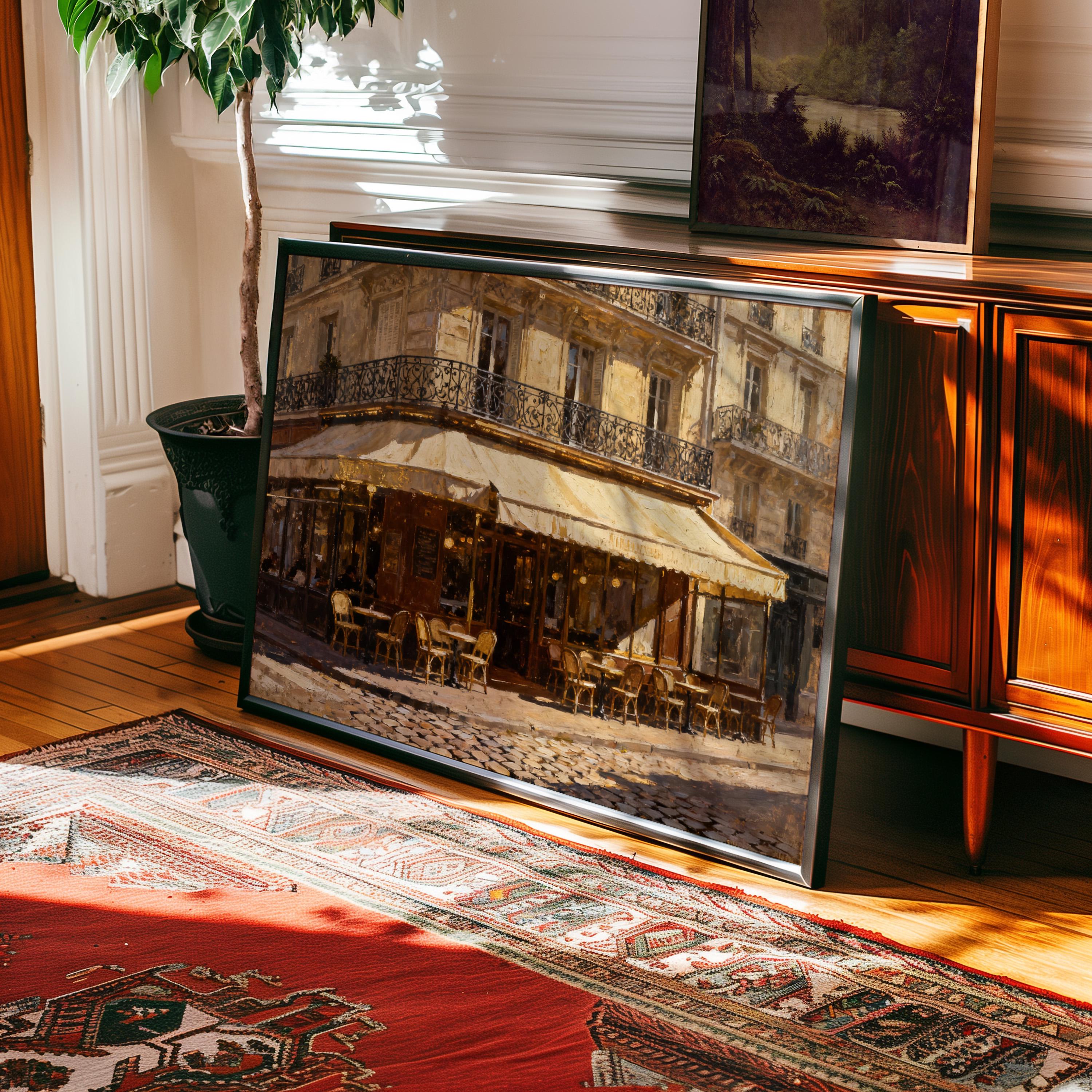 The Vintage Paris Wall Art—Paris Cafe Art Print (framed or unframed)—leans against a wooden cabinet on hardwood floors beside a patterned rug and potted plant, bringing timeless European charm from West & Wild to this sunlit room.