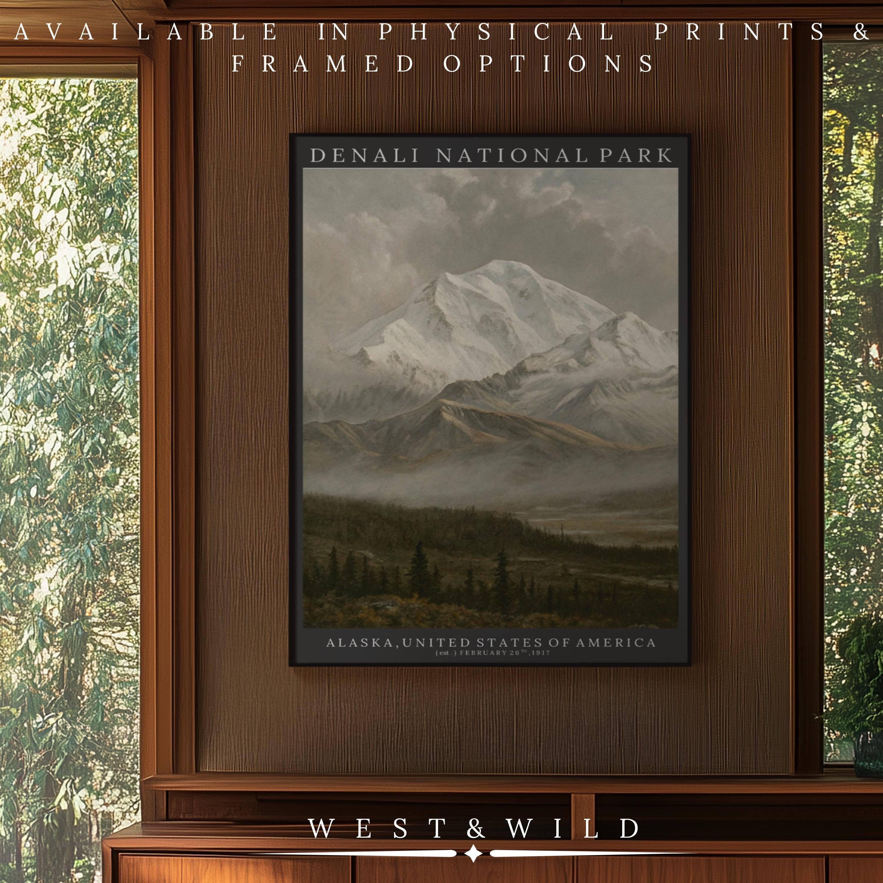 A Denali National Park Print - Alaska Mountain Art | Vintage Nature Poster & Snow Peak Wall Decor by West & Wild Art Archive hangs on a wooden wall, showcasing a snow-capped mountain above forested land. Archival quality and framed options available.