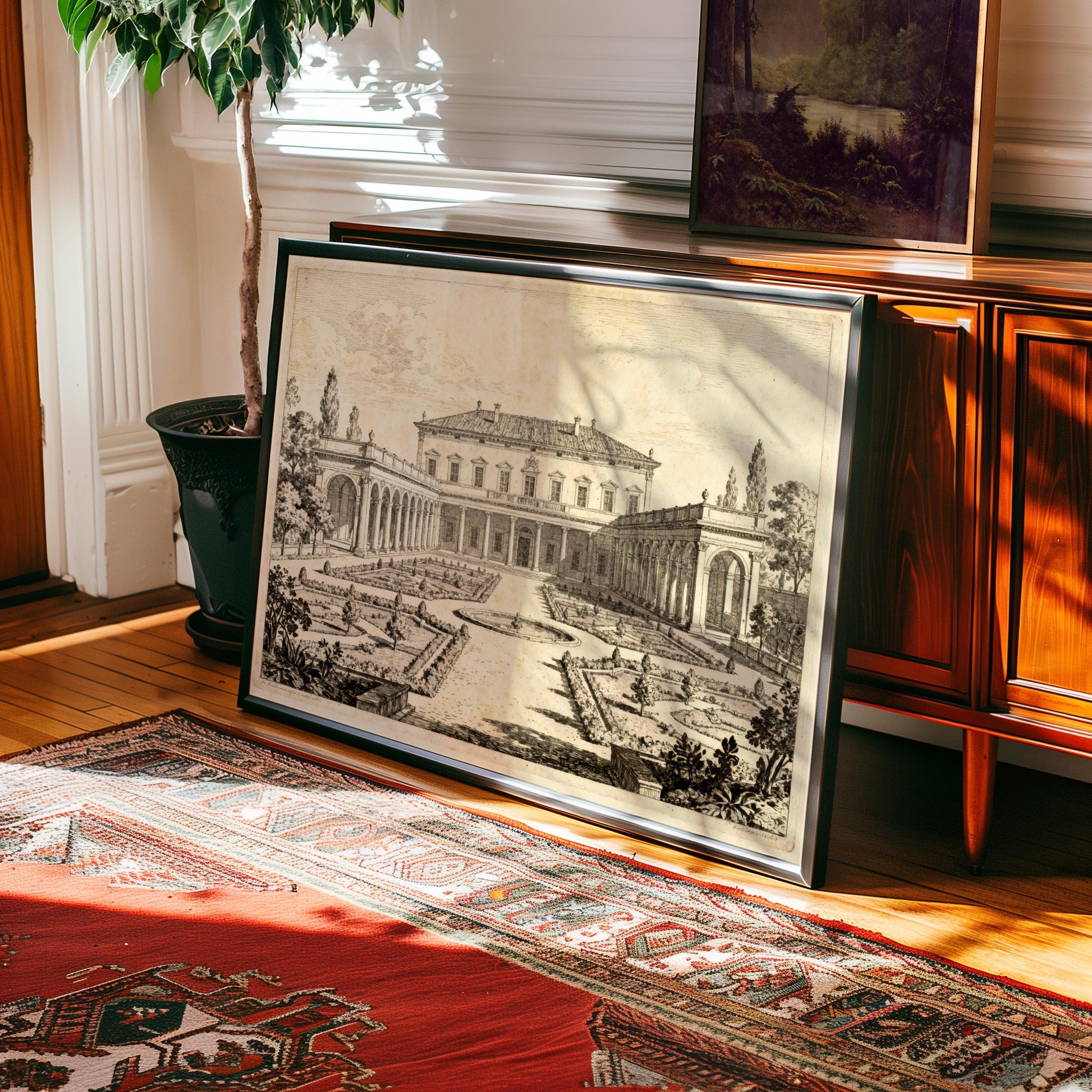 The Italian Villa Art Print—a vintage architectural garden courtyard design in wood and metal frames—rests against a wooden cabinet beside a potted plant and patterned rug, adding timeless elegance to your sunlit room.