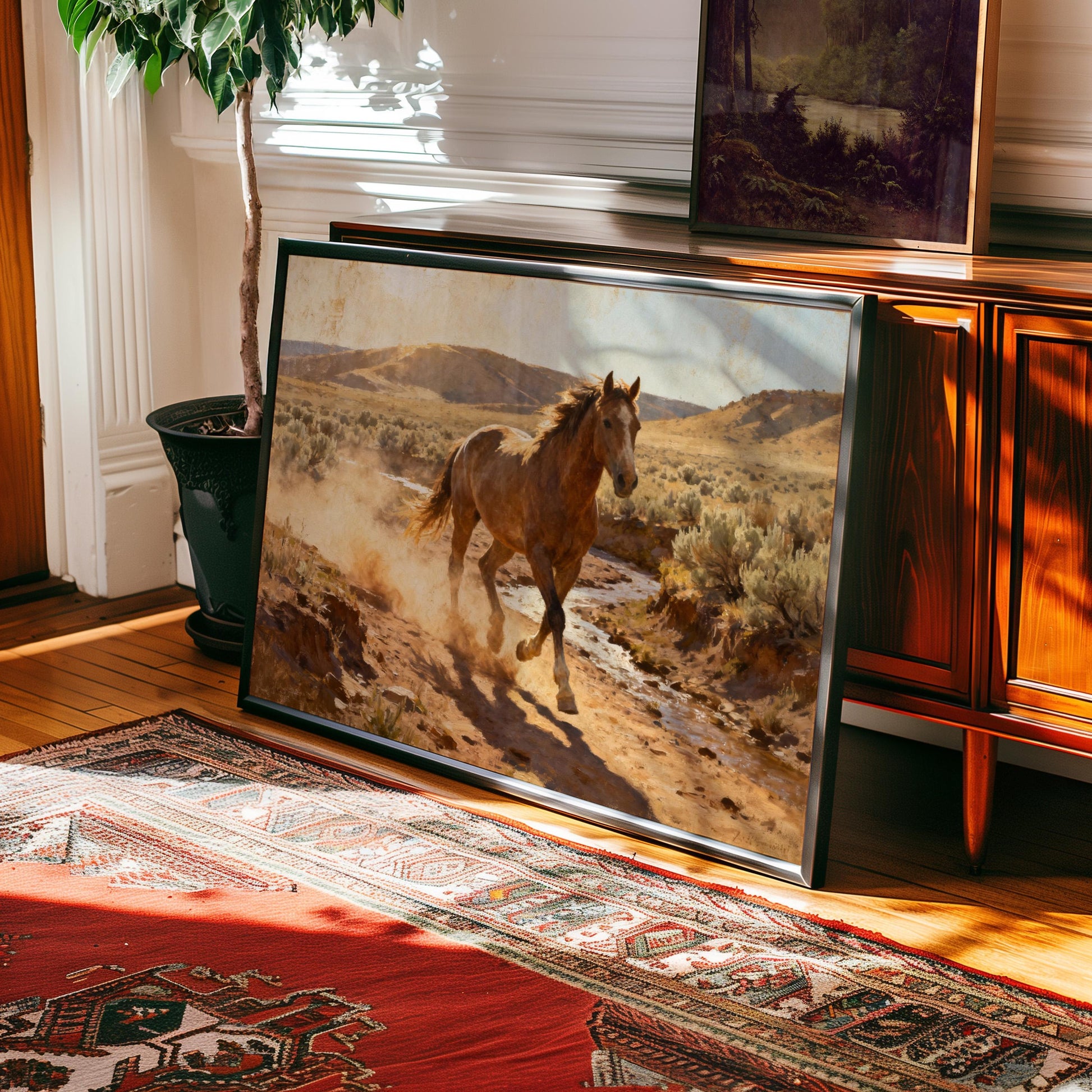 a large framed painting of a horse running on a dirt road, with a wooden cabinet and a potted plant in the background.