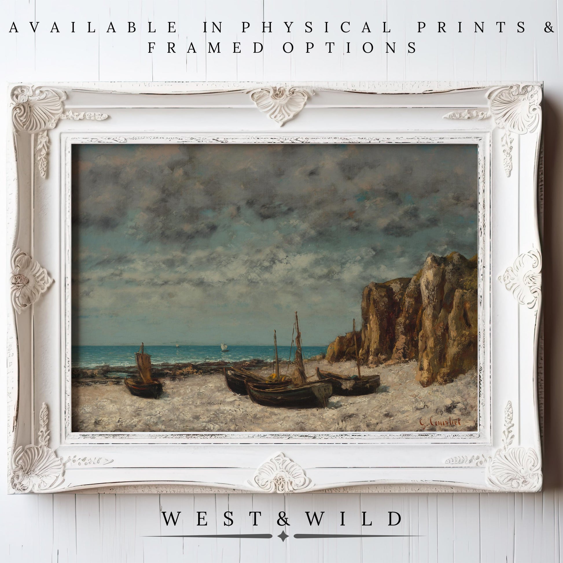 A framed Vintage Ocean Wall Art—Serene Sea Oil Painting Print with rustic frames—shows boats on a sandy shore by rocky cliffs under a cloudy sky. Available as archival-quality prints and framed art from West & Wild Art Archive.