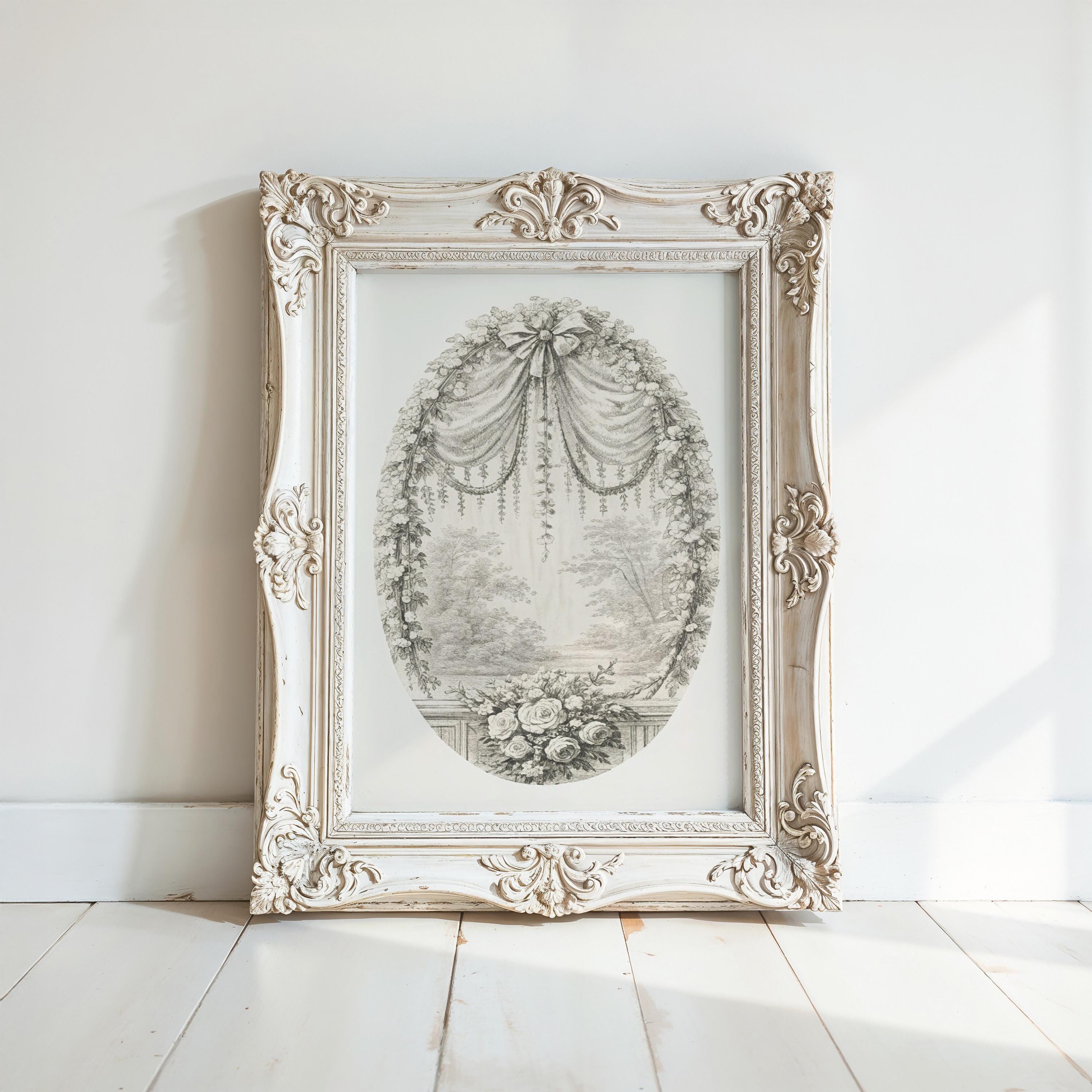 A white ornate frame with a decorative border is displayed against a white wall, containing an oval-shaped illustration of a floral scene.