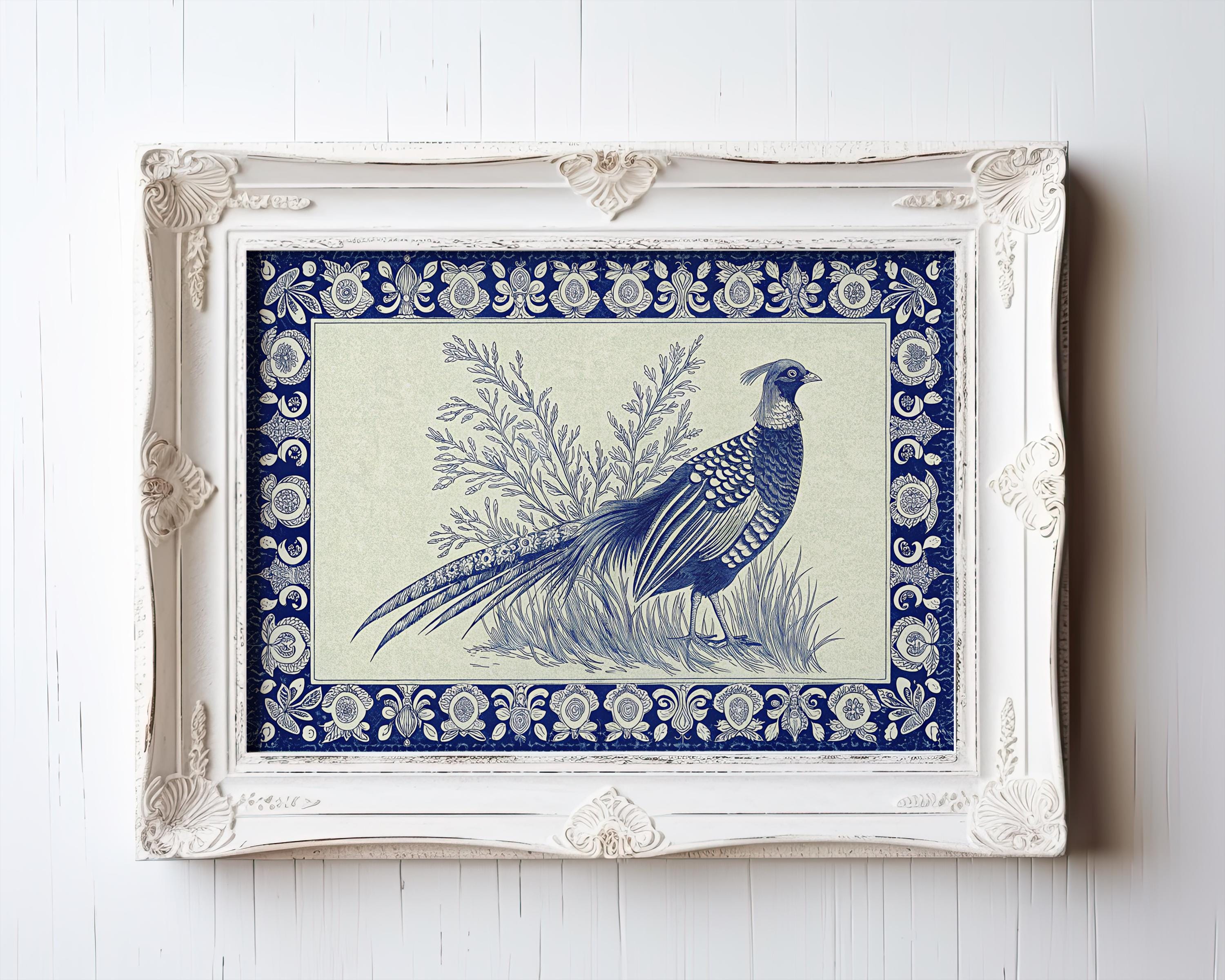 The Framed Pheasant Print - Indigo Vintage Wall Art with Blue Border Decor hangs on a white wall, featuring a blue and white pheasant among foliage in an ornate, carved frame from the Vintage Art Prints & Framed Art collection.