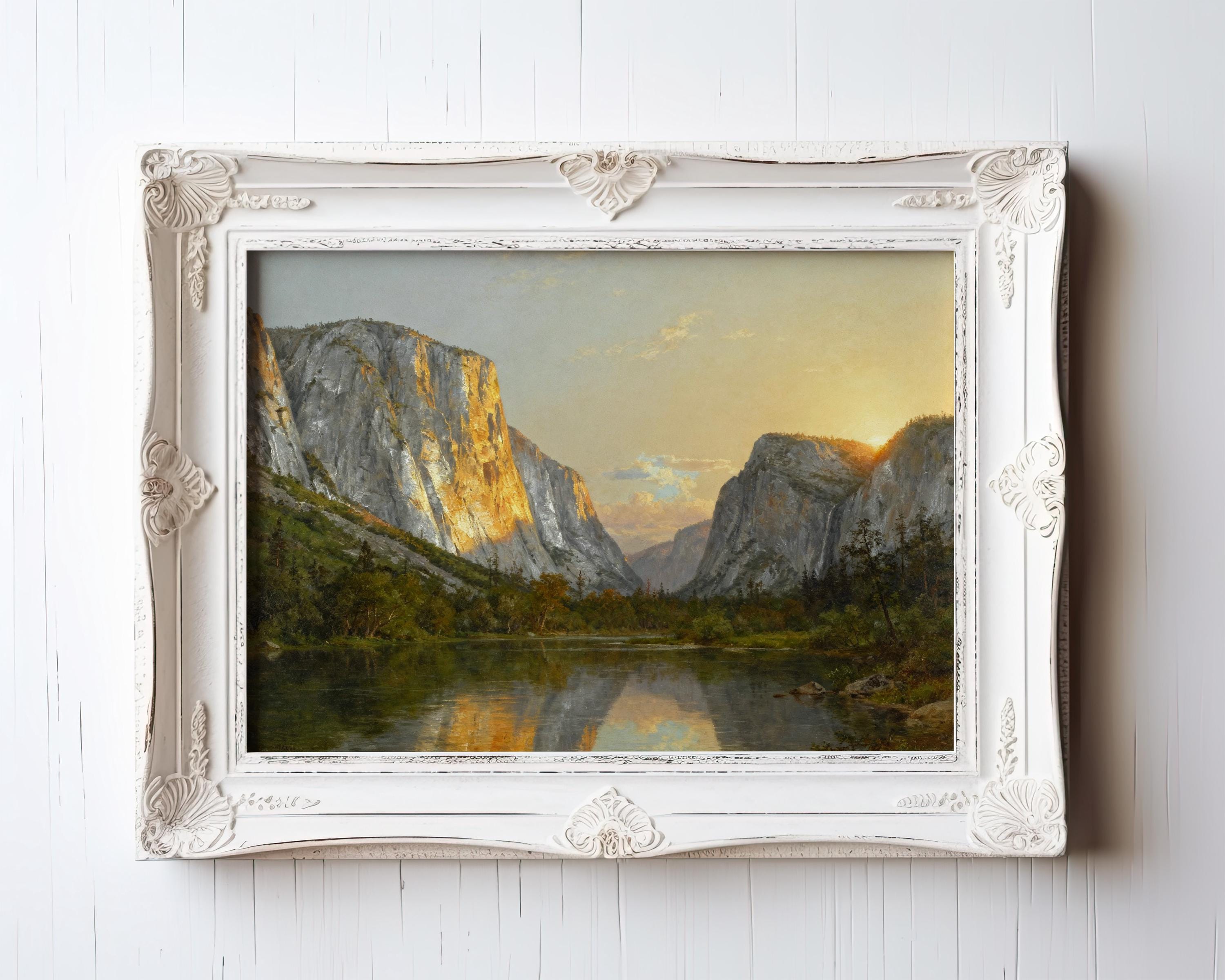 The image is a framed painting depicting a serene landscape with a lake surrounded by mountains and a sunset sky.