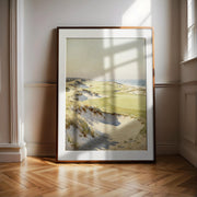 A large framed painting depicting a serene landscape with rolling hills, dunes, and a body of water is displayed on a wooden floor in a room with white walls.