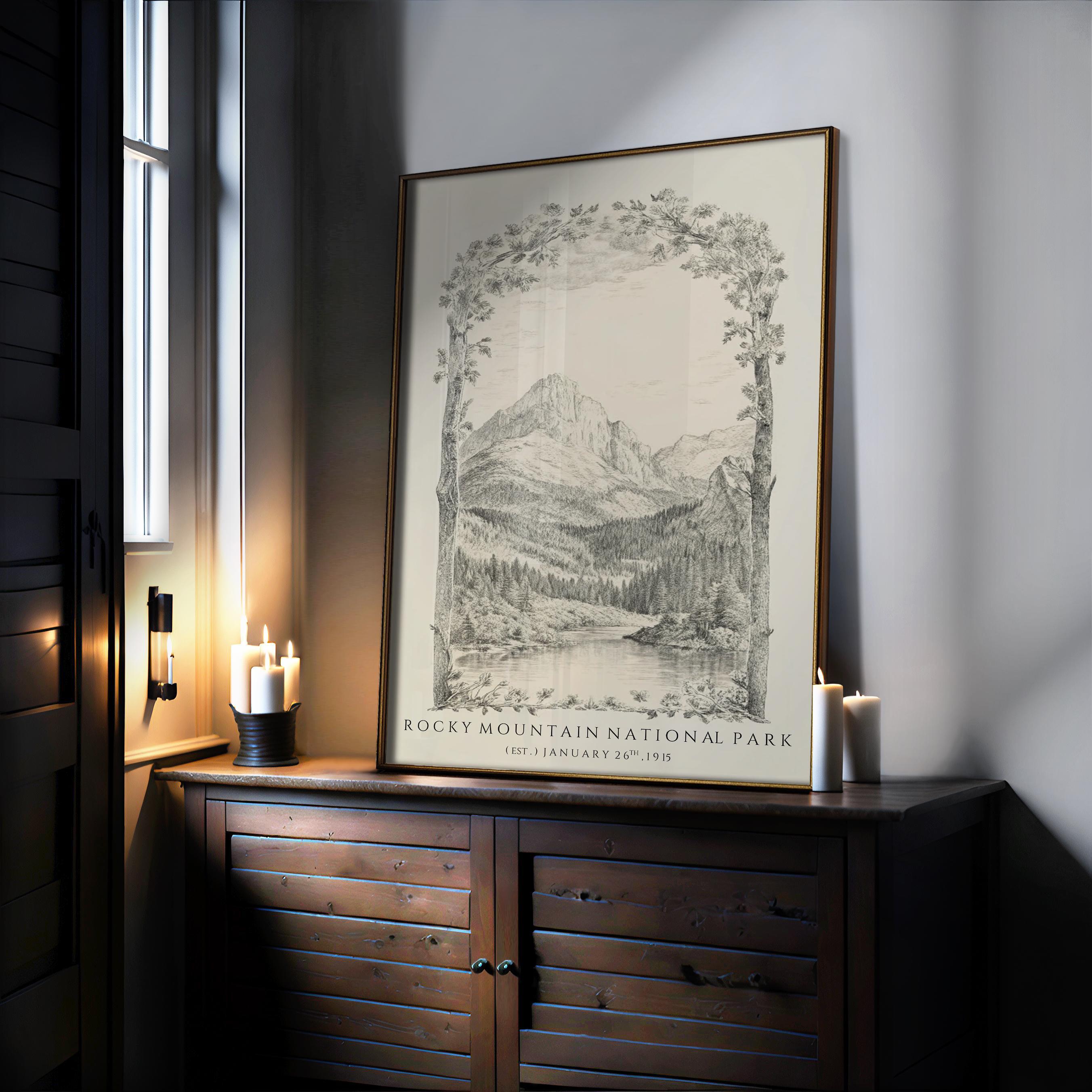 The Rocky Mountain Poster – Vintage Wall Decor with Colorado mountain art and wood frame options – sits on a wooden cabinet near lit candles, illuminated by soft natural light. The archival-quality print features mountains, trees, and text below.