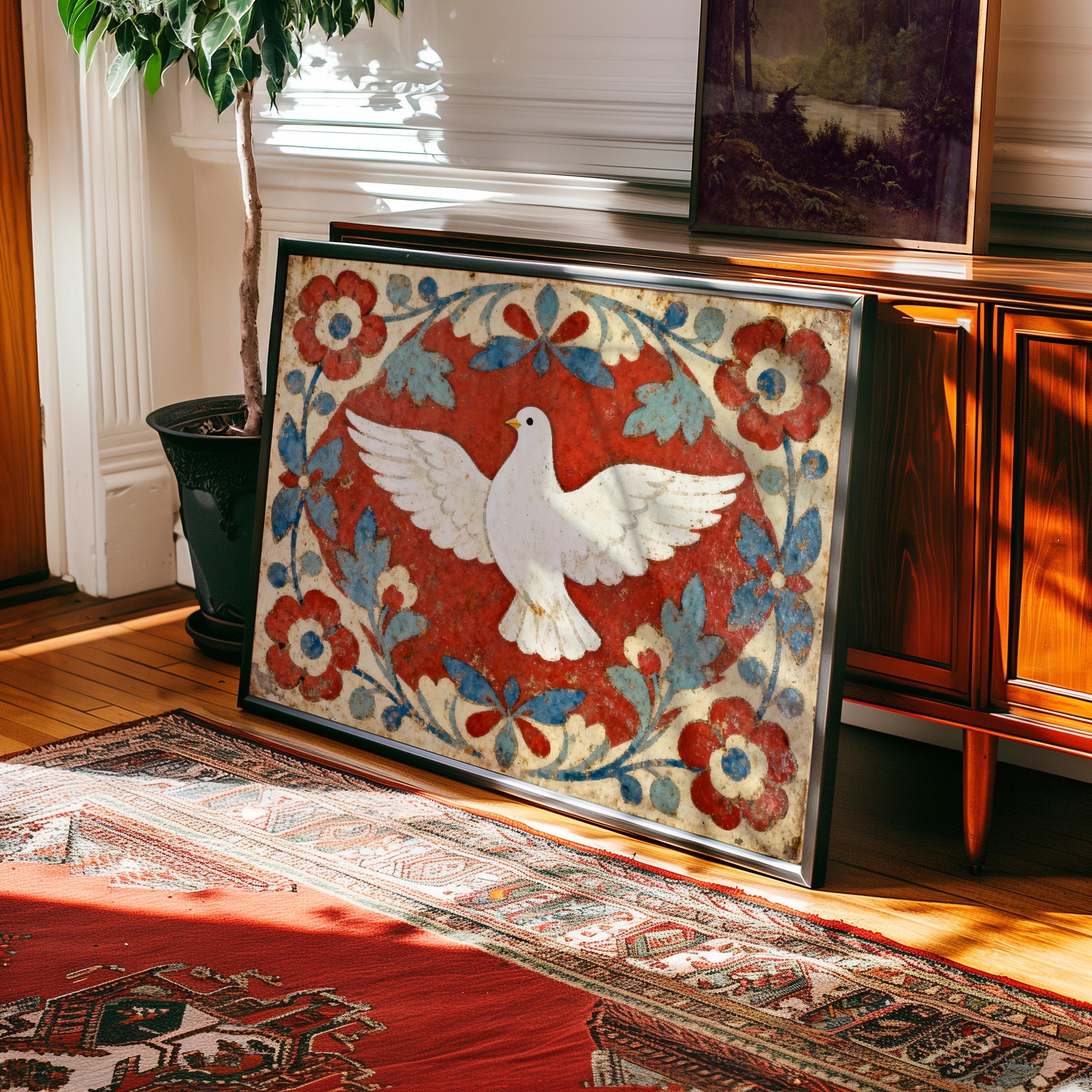 A Folk Dove Art Print – Vintage Red Blue Folk Design rests framed against a wooden cabinet in a sunlit room with a patterned rug and potted plant, adding rustic Americana charm with its colorful floral and white dove motif.