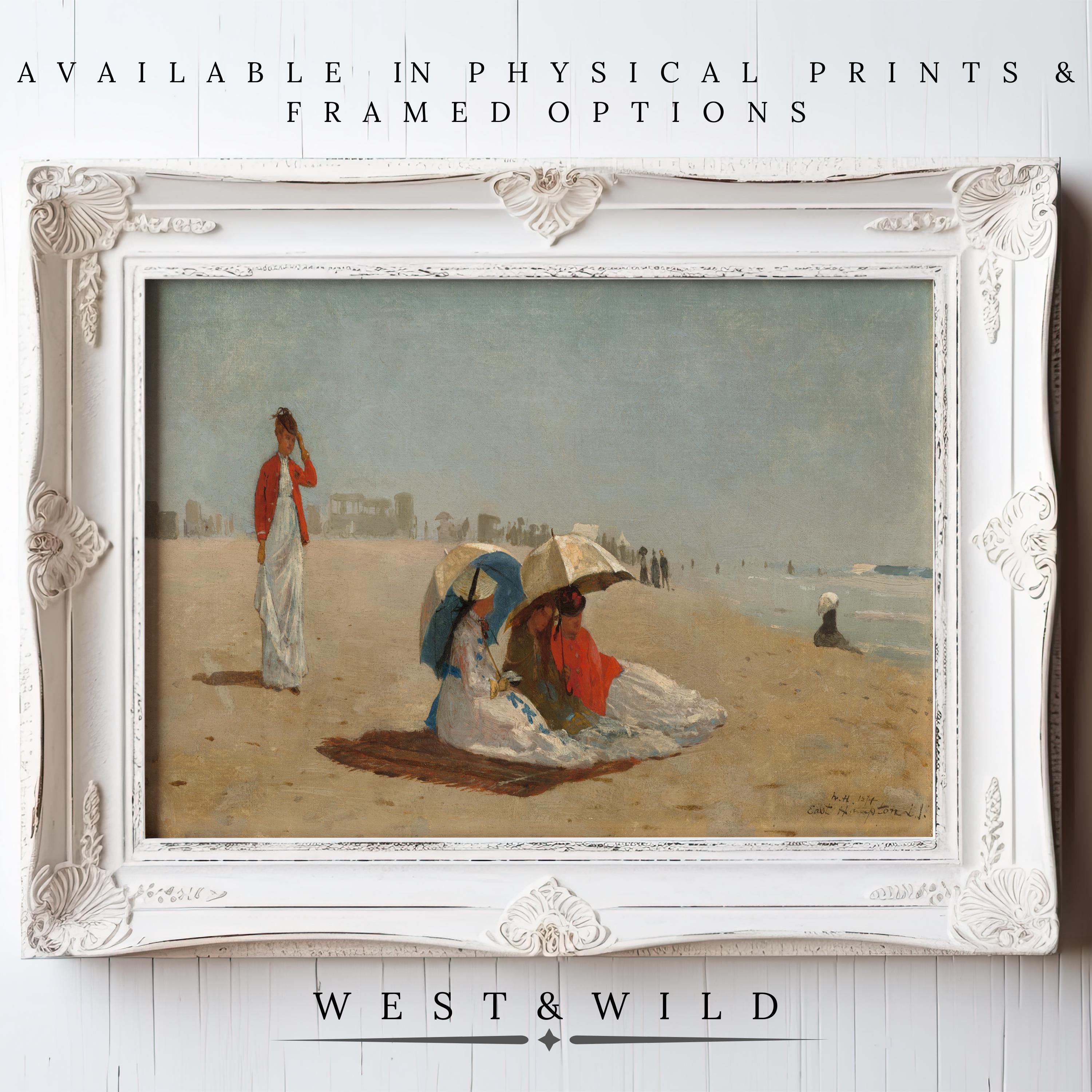 Victorian Beach Art – Vintage Wall Prints. Classic ocean painting featuring women in dresses and hats on a sandy beach, shown in an ornate white frame against a white wooden wall. Archival quality. Available as prints & framed art from West & Wild Art Archive.
