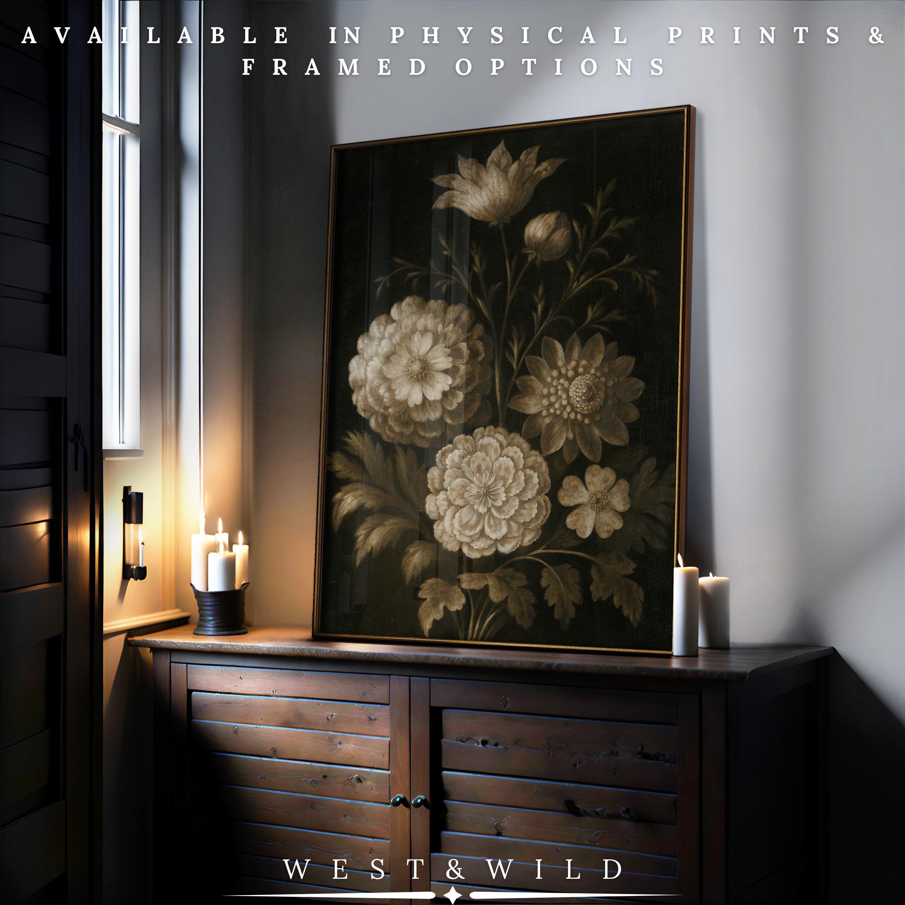 A Sepia Botanical Print – Framed Vintage Floral Illustration rests on a wooden cabinet by a window, lit candles nearby. Text above reads Available in physical prints & framed options. Below: West & Wild Art Archive.