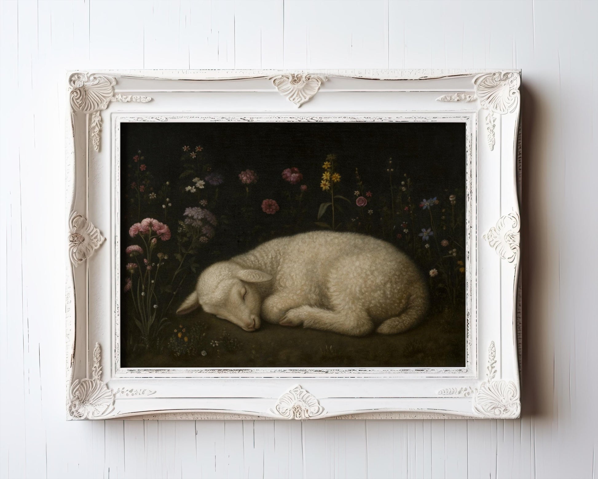 A Vintage Lamb Art Print – Sleeping Lamb Among Flowers hangs on a white wall in an ornate white antique-style frame—an archival piece from the West & Wild Art Archive.
