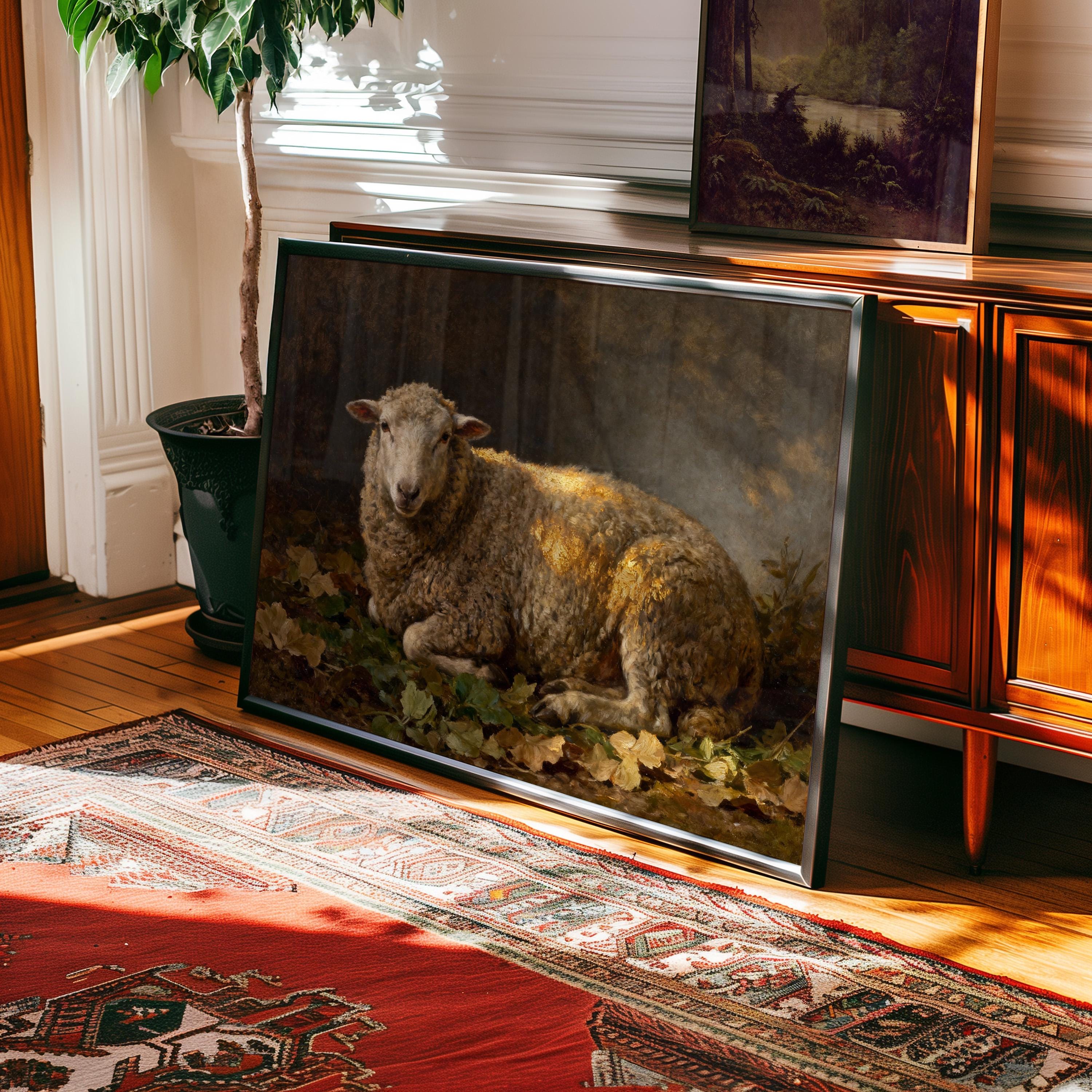 The Resting Sheep Art Print—Vintage Farmhouse Wall Art with Warm Earth Tones—rests framed against a wooden cabinet on a hardwood floor beside a potted plant and patterned rug, adding charm and warmth to your space.