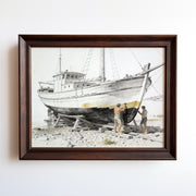 Watercolor print of a fishing boat beached on a rocky shore with weathered rigging