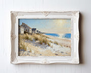 The image is a painting of a beach scene with houses and dunes in the background, framed in a white ornate frame.