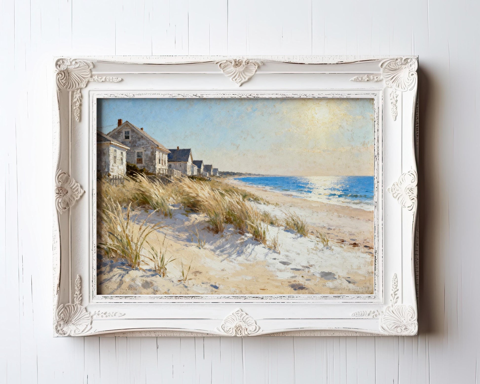 The image is a painting of a beach scene with houses and dunes in the background, framed in a white ornate frame.