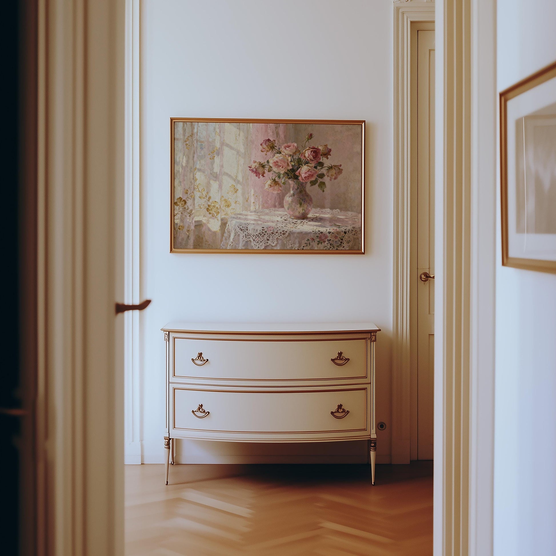 a hallway with a white dresser and a framed painting of flowers hanging on the wall above it.