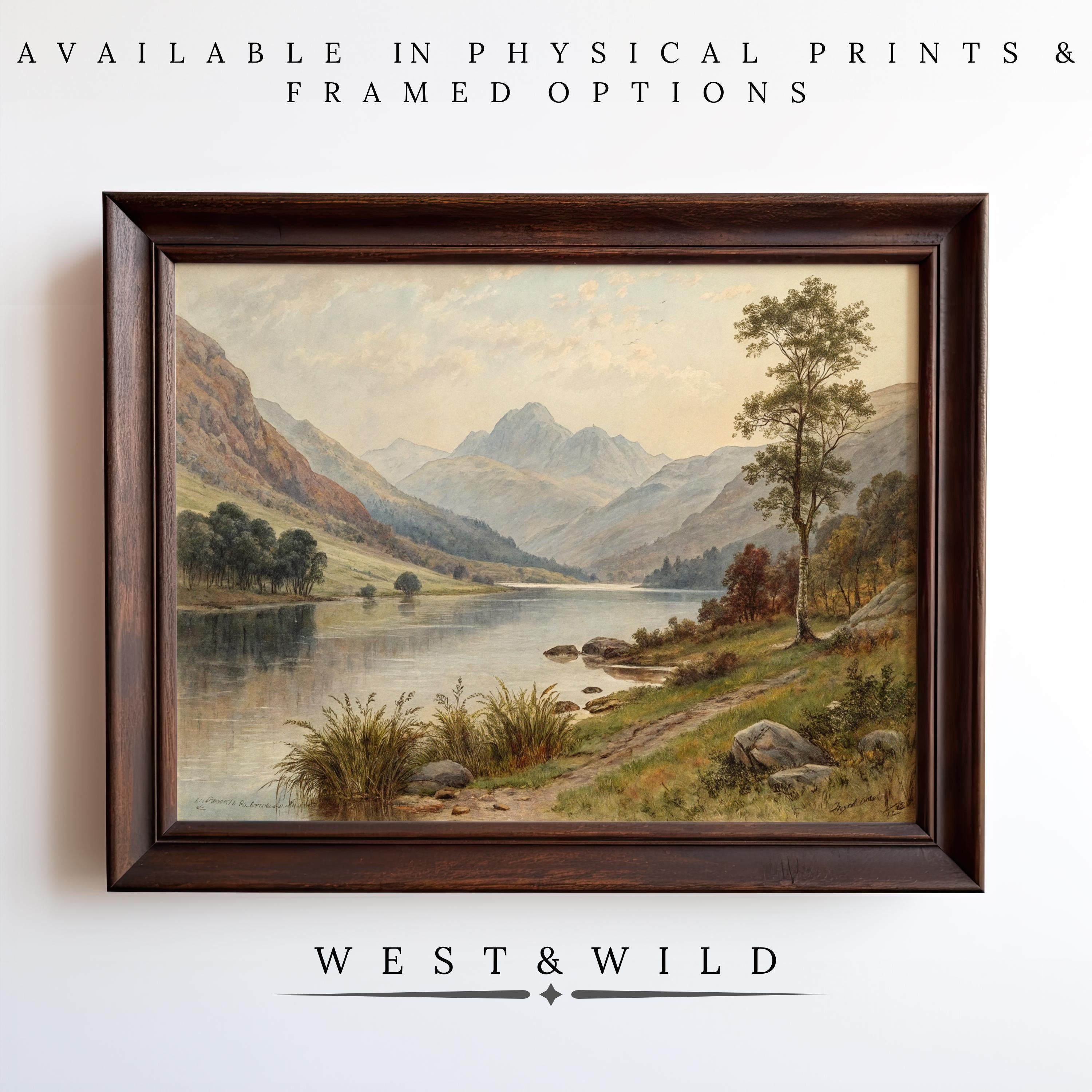 A framed Mountain Lake Painting featuring a river, trees, and mountains hangs on a white wall. Available in archival quality vintage prints & rustic wood frame options. Below: West & Wild Art Archive.