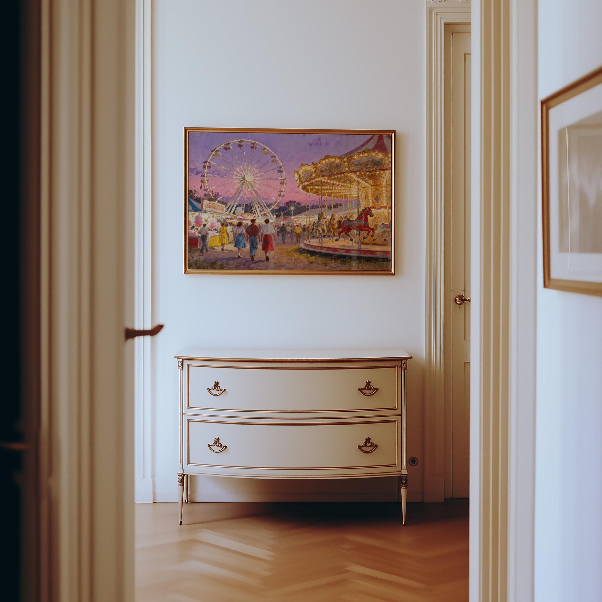 A cream-colored dresser stands against a white wall in a hallway, topped by the Vintage County Fair Print – a retro carnival poster featuring a Ferris wheel, with light wood flooring and partially visible doors.