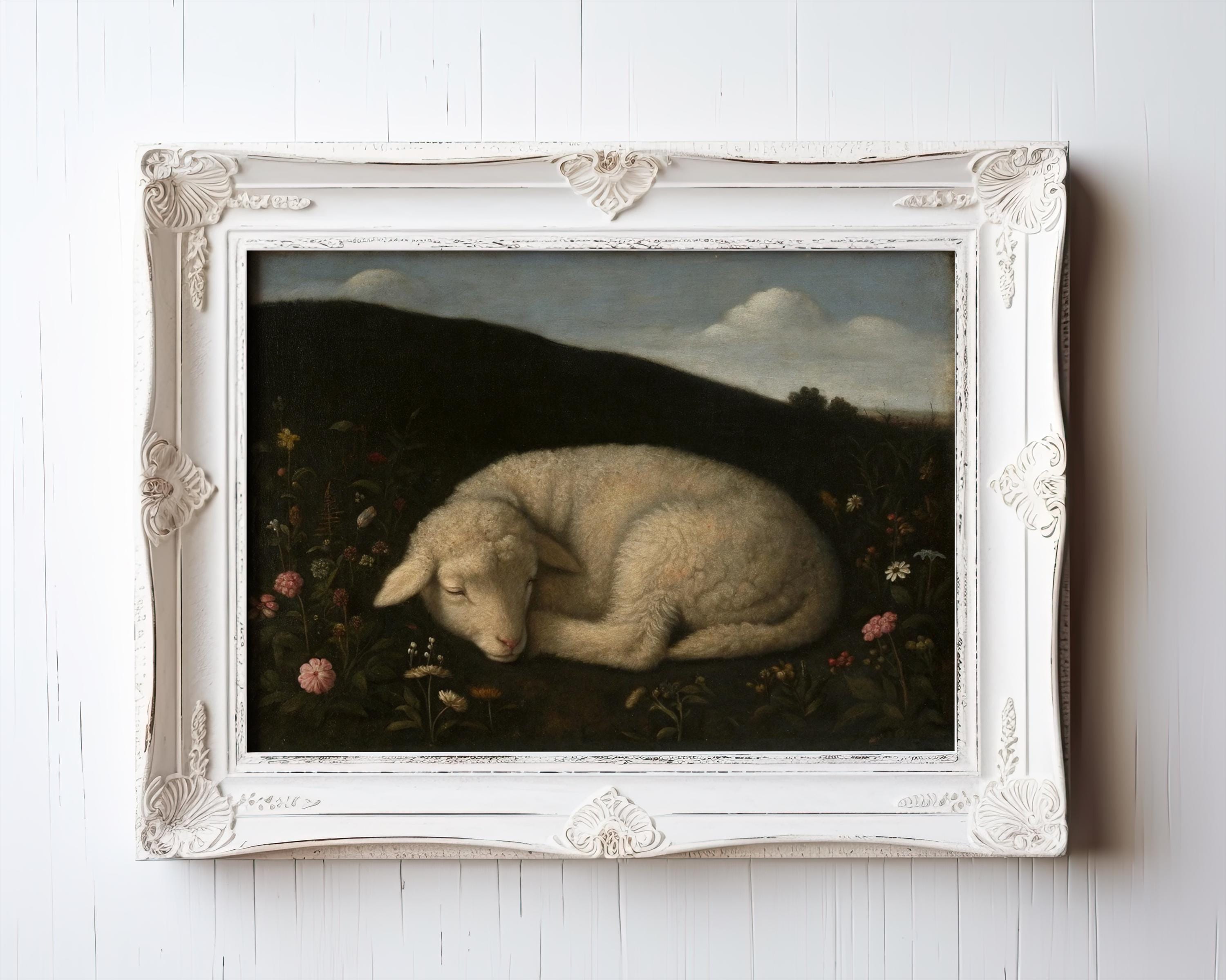 The Vintage Lamb Wall Art features a sleeping lamb among meadow flowers under a moody sky, framed in ornate white. This archival-quality print from the West & Wild Art Archive adds rustic charm to any nursery or space.