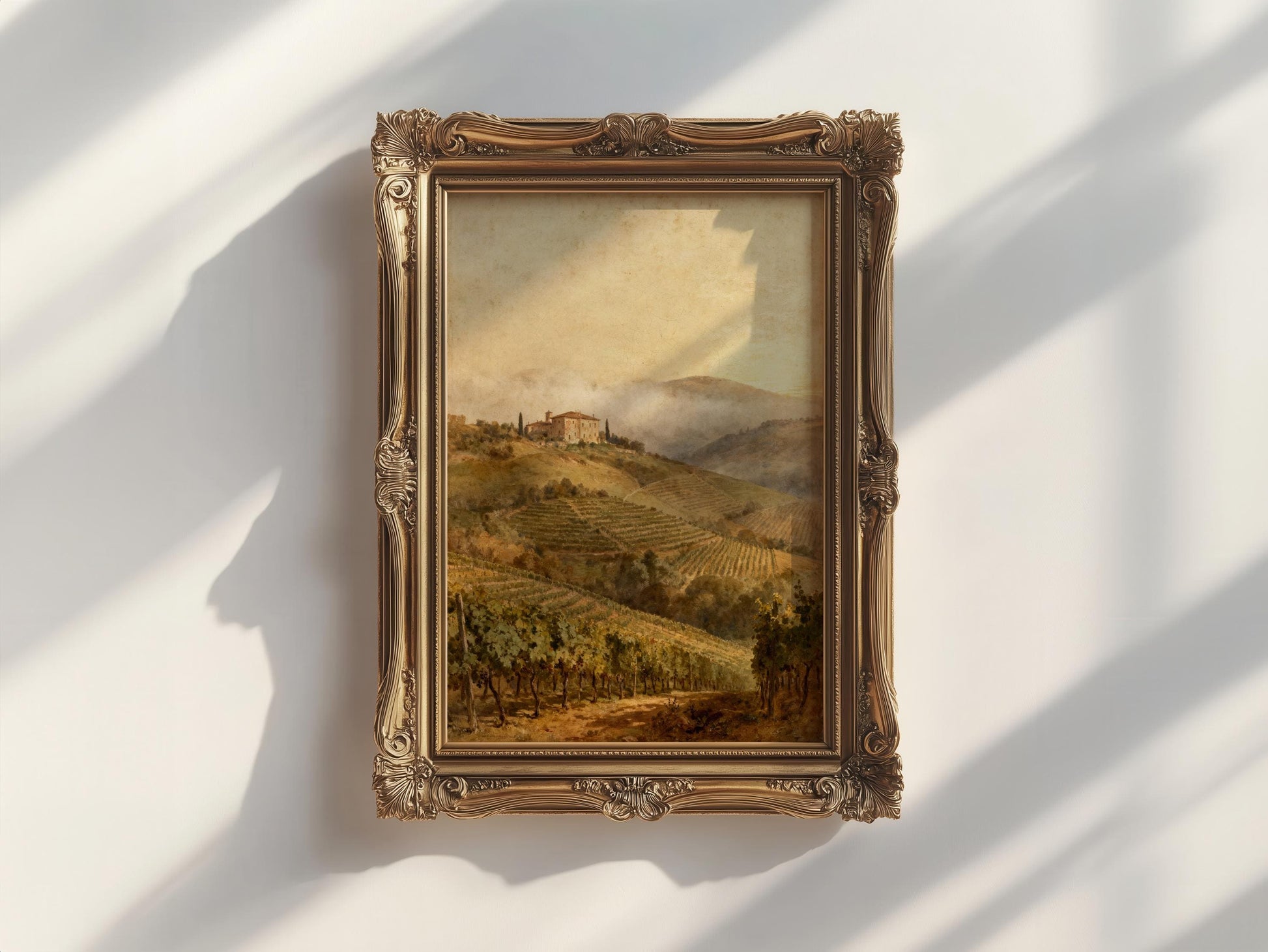 a painting of a countryside landscape, hanging on a white wall.