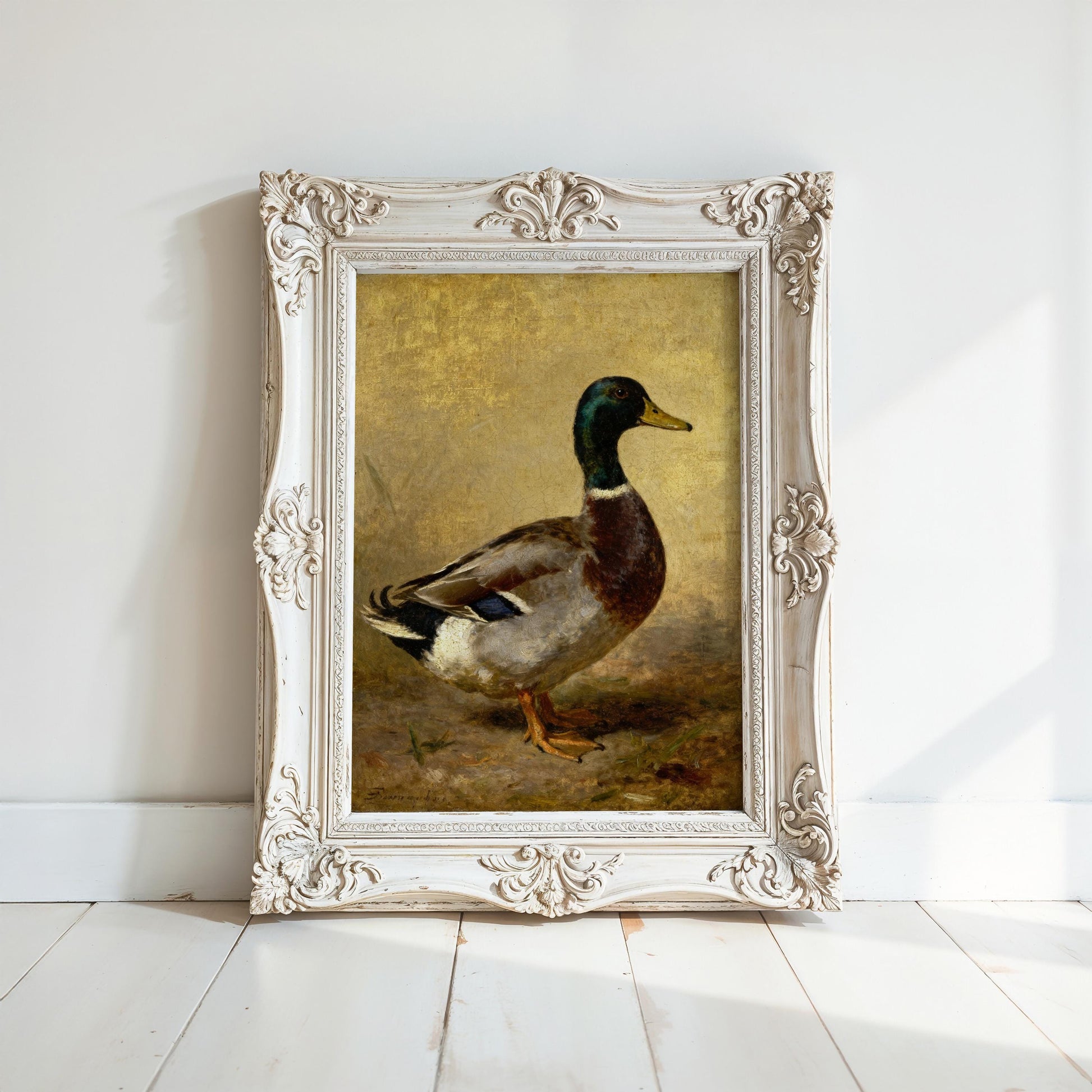 a painting of a duck in a white ornate frame, displayed on a white wall.