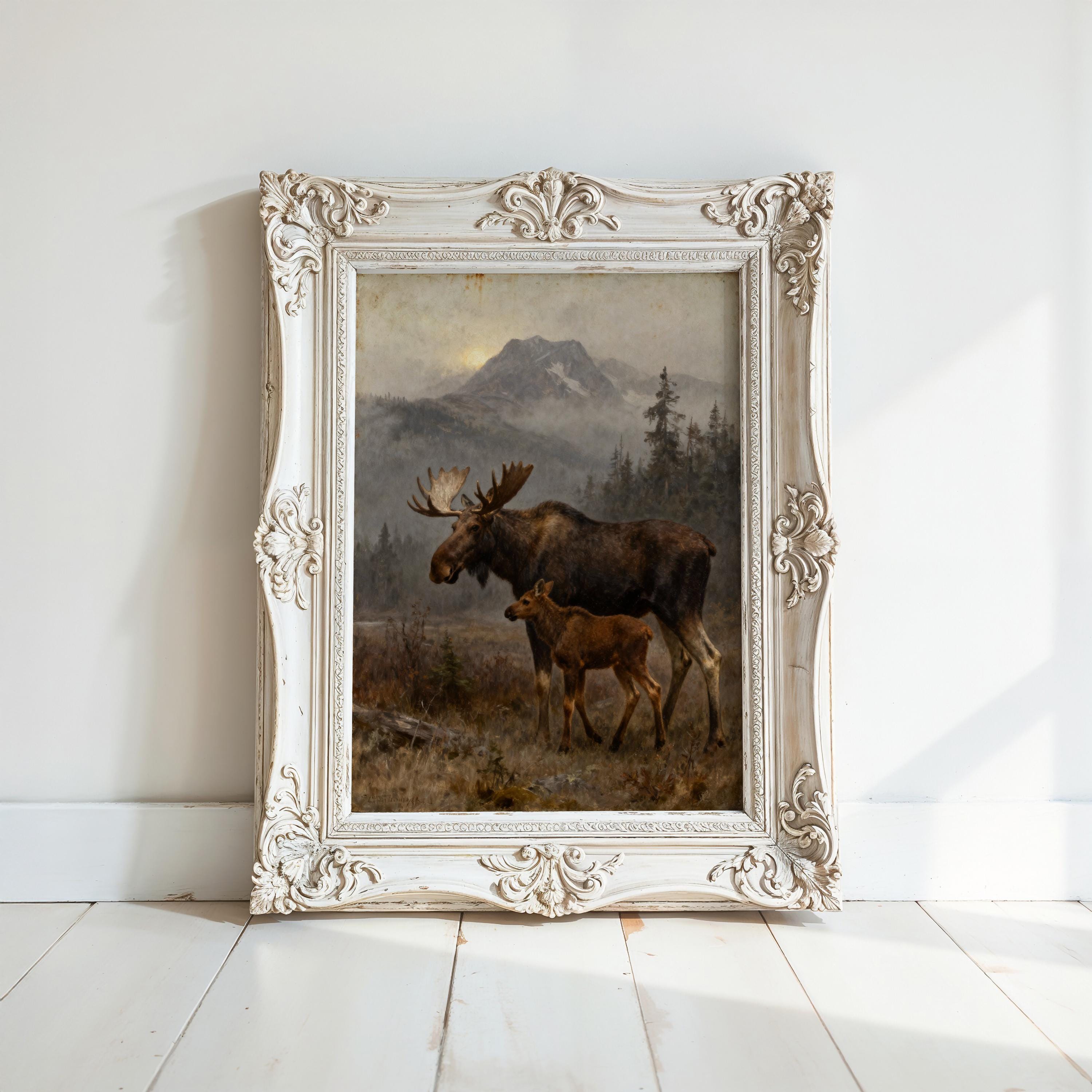 A painting of a moose and its calf in a forest setting, framed in an ornate white frame.