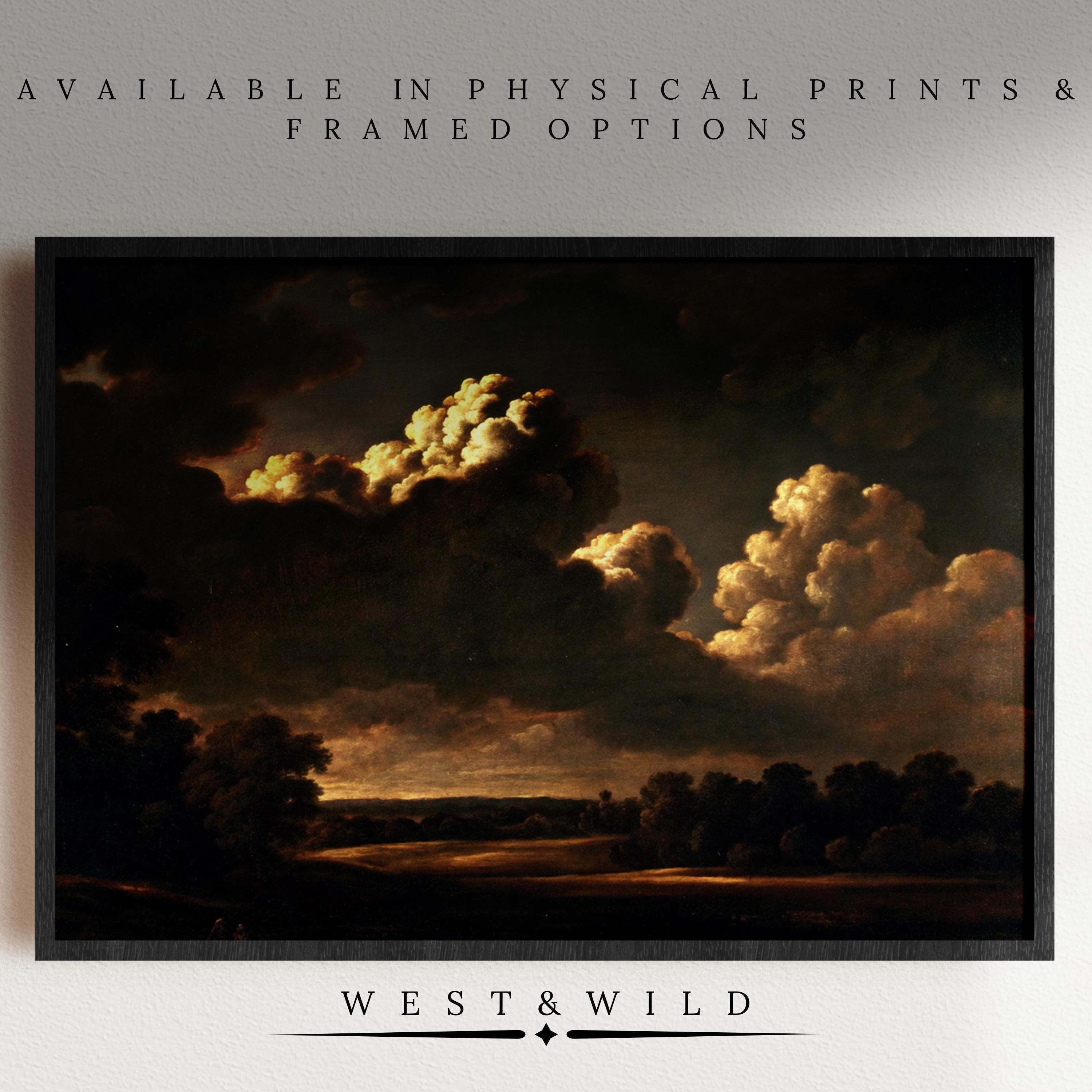 Dramatic Sunset Clouds Moody Sky Art – a vintage-inspired, museum grade print featuring glowing clouds over a shadowed forest, presented in a black frame. Available as prints and framed art. Above: Available in physical prints & framed options. Below: West & Wild.