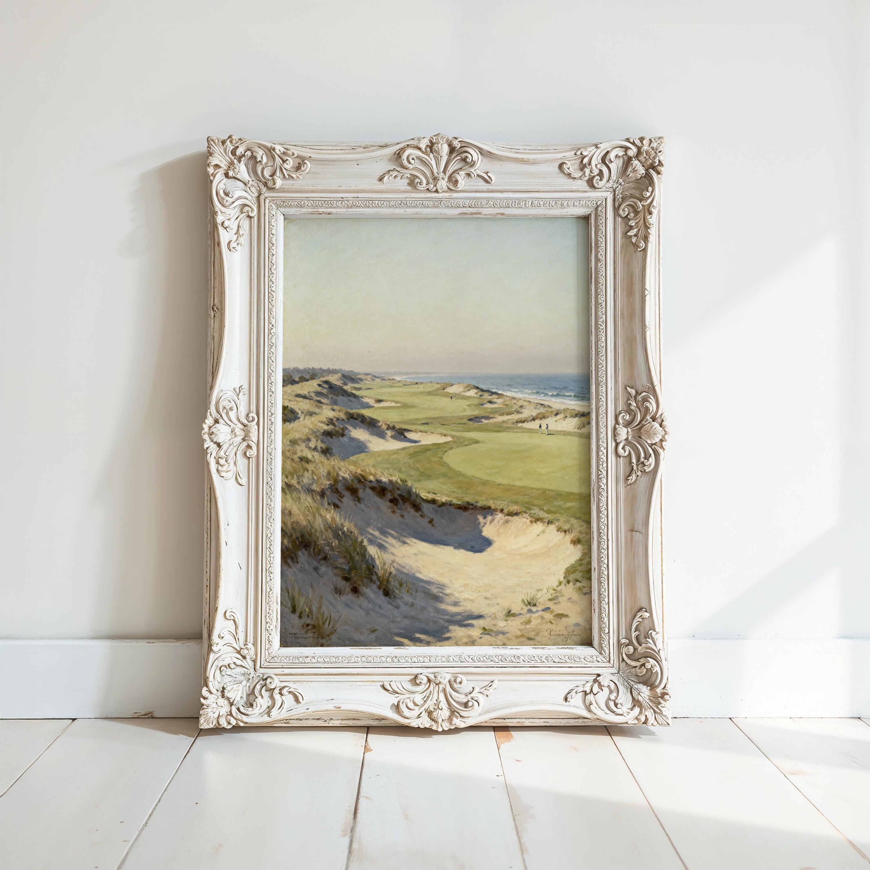 a painting of a landscape with a beach and grassy field, displayed in an ornate white frame on a white wall.