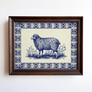 The Framed Sheep Print – Blue China Pattern Rustic Wall Art features a sheep among plants with an ornate blue and white border, presented in your choice of wood or metal frame. Vintage archival print from West & Wild Art Archive.