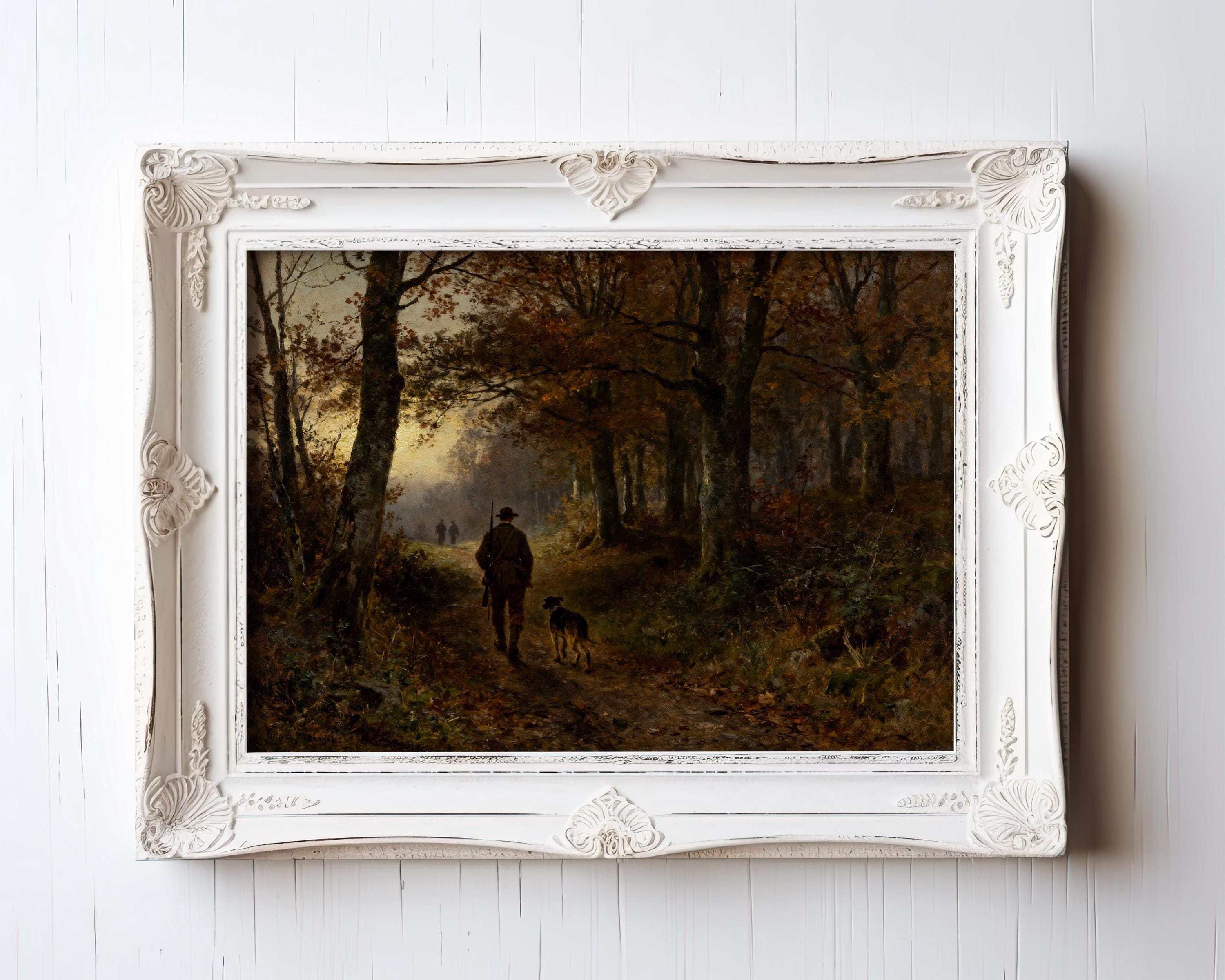 A white ornate-framed "Hunter Dog Art Print – Vintage Autumn Forest Scene" from West & Wild Art Archive hangs on a white wall, showing a person walking a dog in autumn woods with sunlight streaming through the trees.