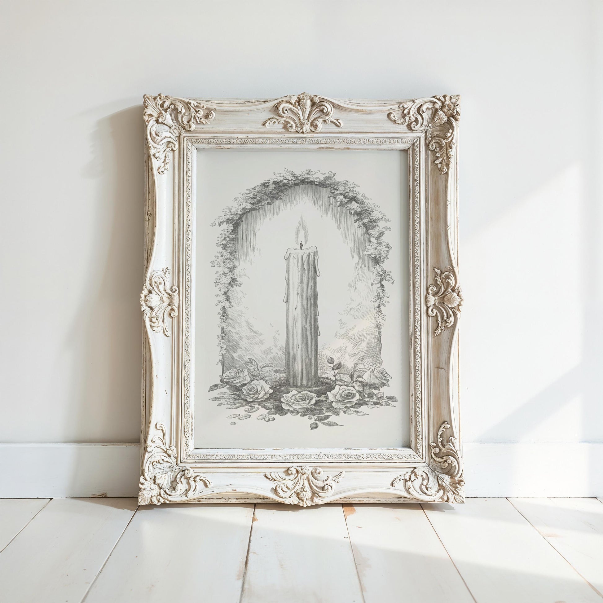 A white ornate picture frame with a candle drawing inside it, placed on a white wooden floor against a white wall.
