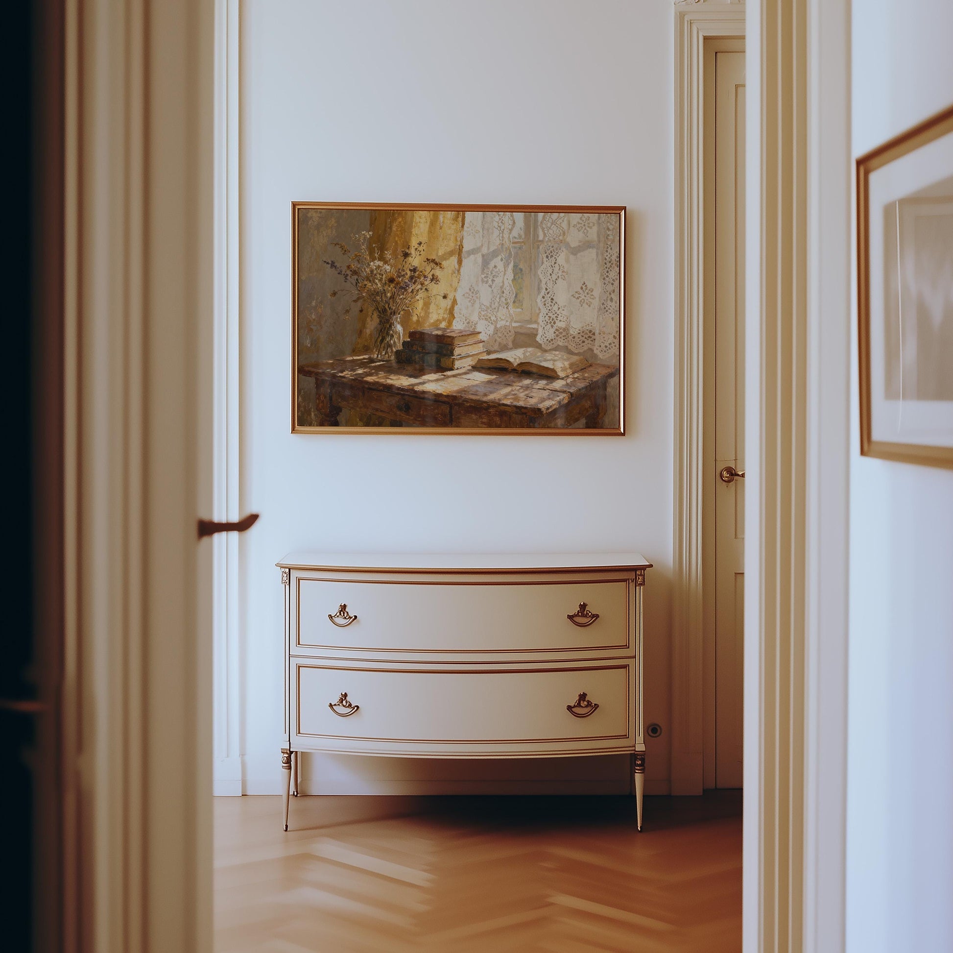 a hallway with a white dresser and a framed painting hanging on the wall above it.