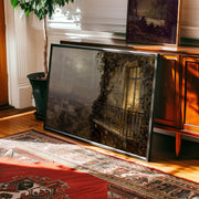 The Paris Balcony Art Print – Vintage Cityscape Artwork with Archival Matte Finish rests against a wooden cabinet beside a potted plant, adding charm to a sunlit room—premium décor from West & Wild Art Archive.