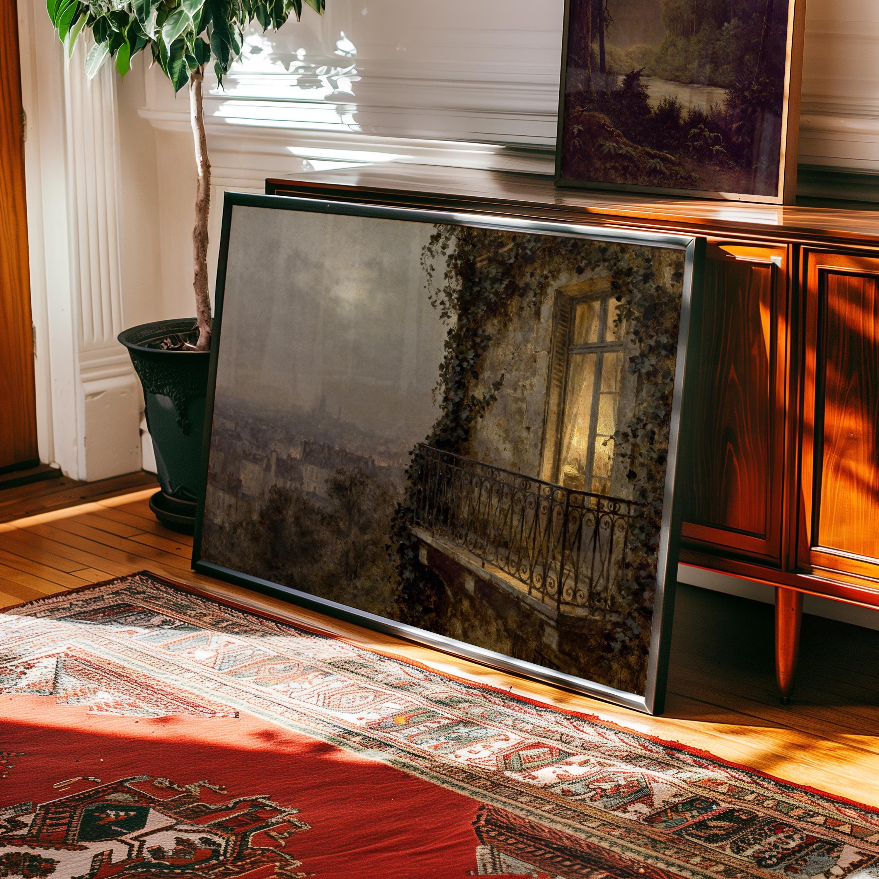 The Paris Balcony Art Print – Vintage Cityscape Artwork with Archival Matte Finish rests against a wooden cabinet beside a potted plant, adding charm to a sunlit room—premium décor from West & Wild Art Archive.