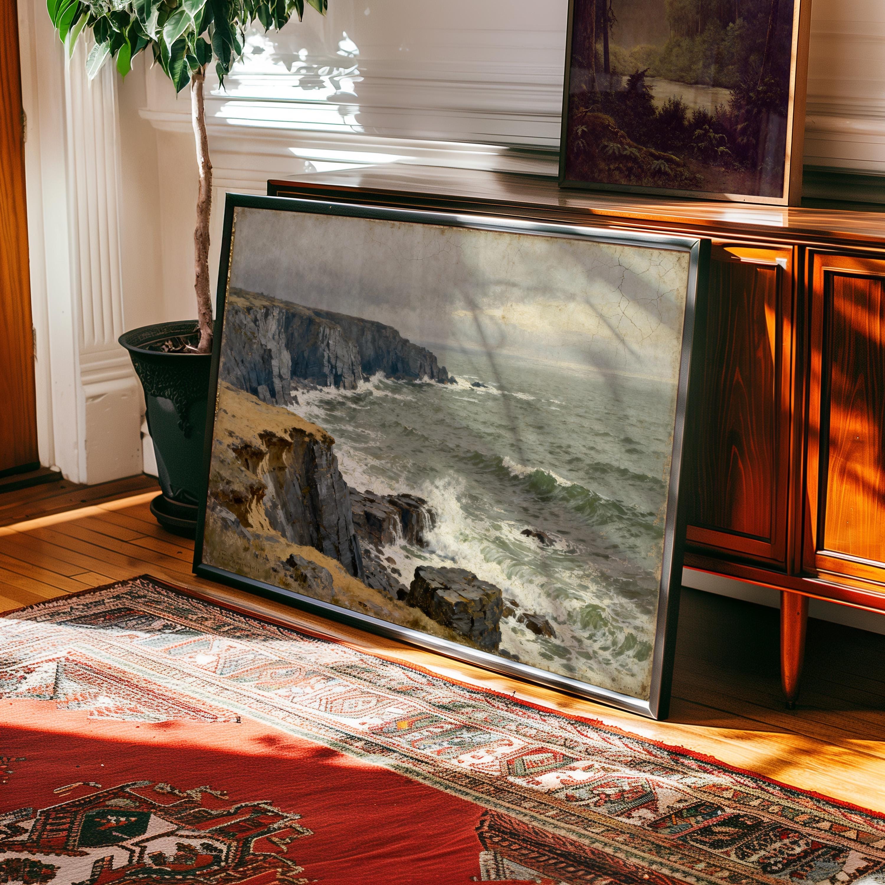 a large framed painting of a rocky coastline with crashing waves, displayed on a wooden cabinet in a room with a rug and a potted plant.