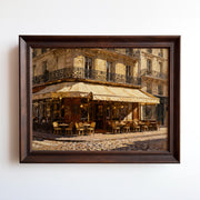 The Vintage Paris Wall Art – a framed or unframed European print from the West & Wild Art Archive – features a Paris café on a cobblestone street, glowing lights, a cream awning, and charming balconies above.